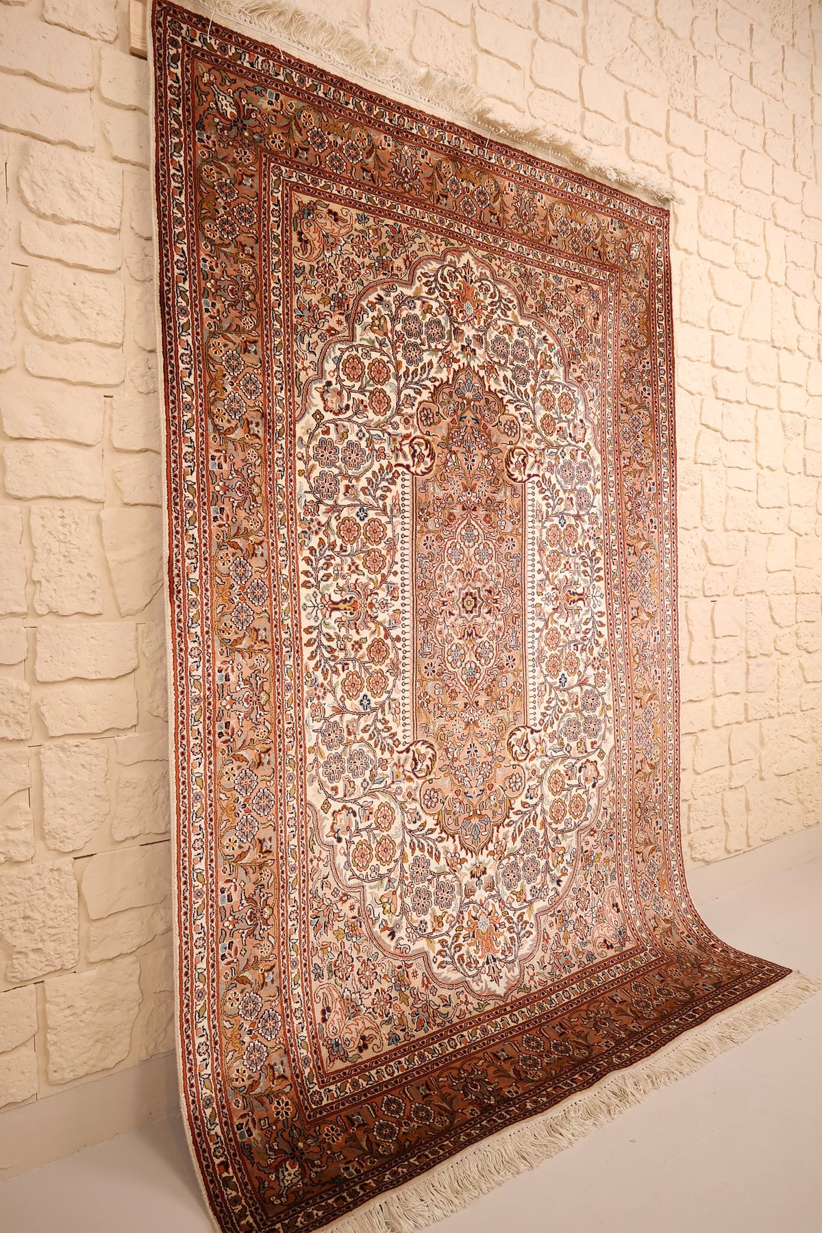Tapis Cachemire en soie noué à la main, vue de biais sur le champ ivoire et les bordures