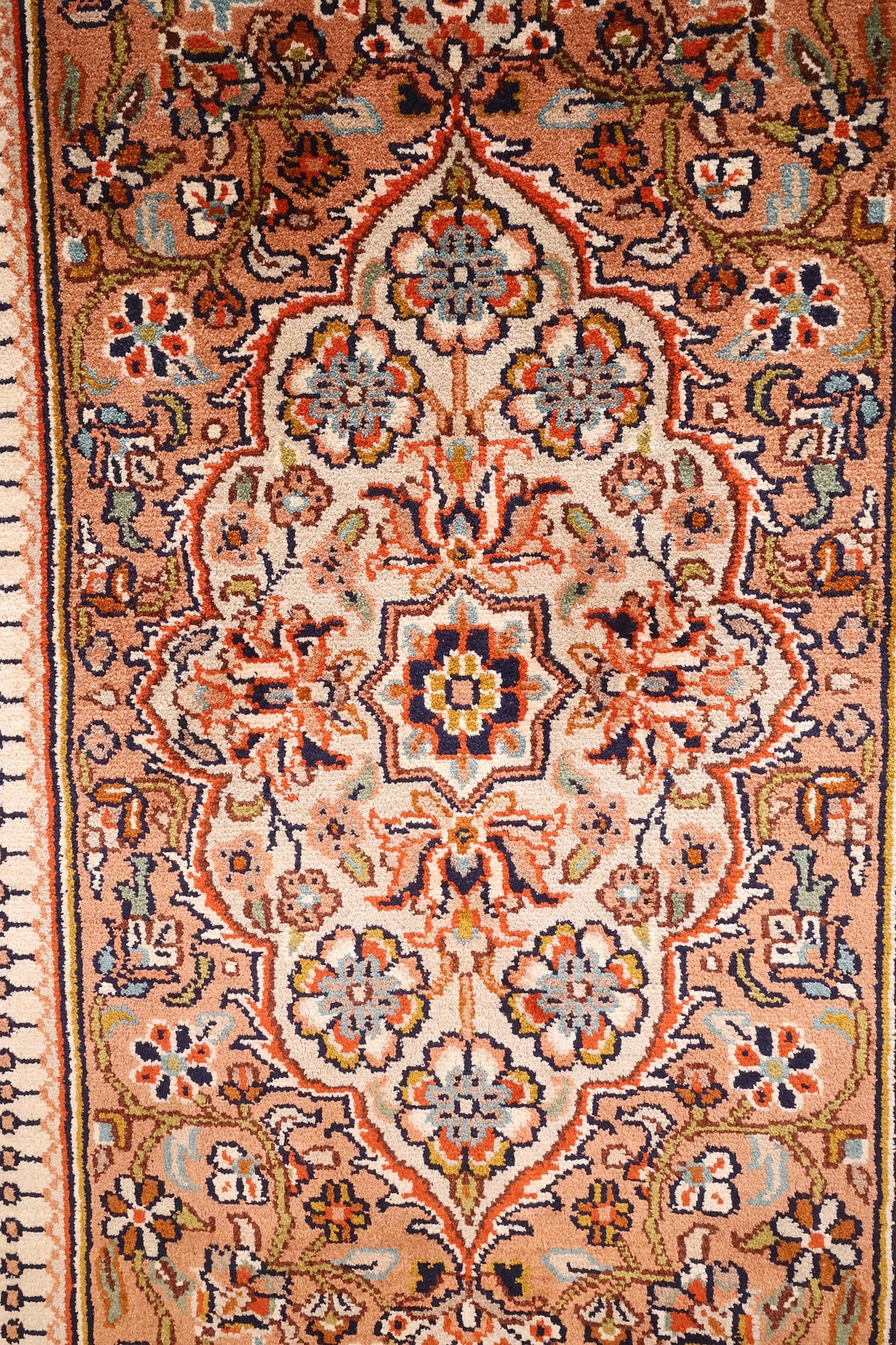 Gros plan des palmettes et fleurs bleu clair cernées de bleu nuit, tapis Cachemire soie