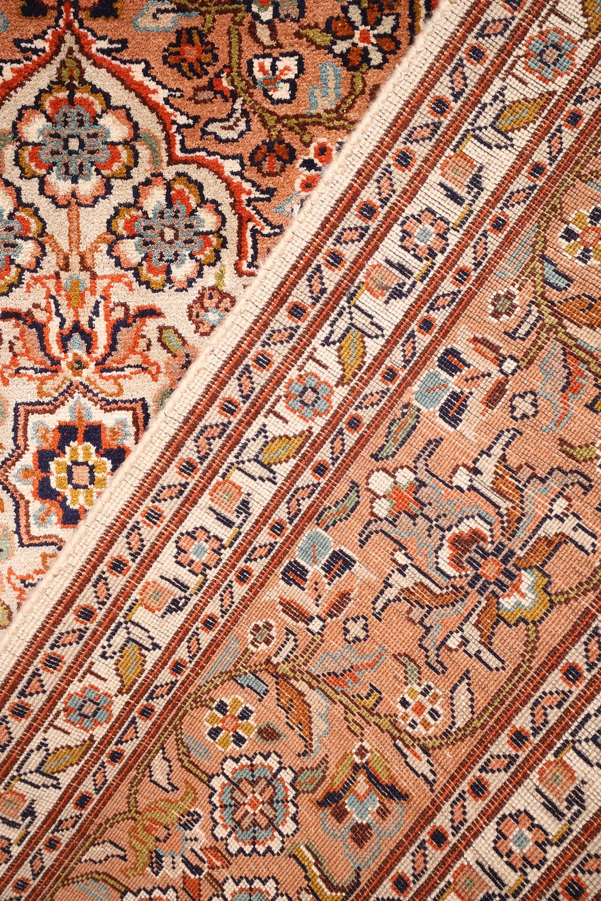 Coin replié du tapis Cachemire beige et orange, galons floraux en soie
