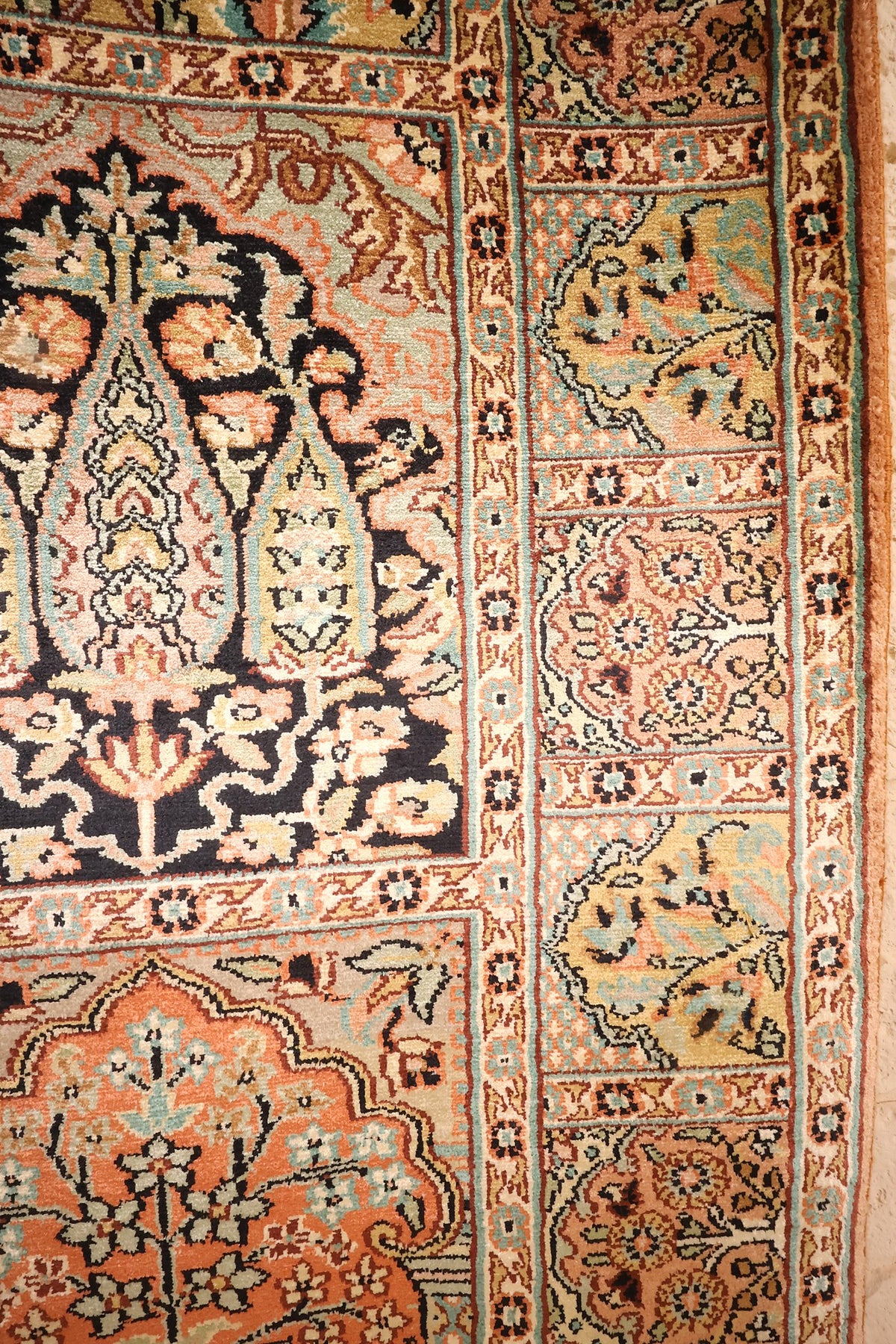 Motif d'arcade fleurie sur fond noir et bordure claire du tapis Cachemire