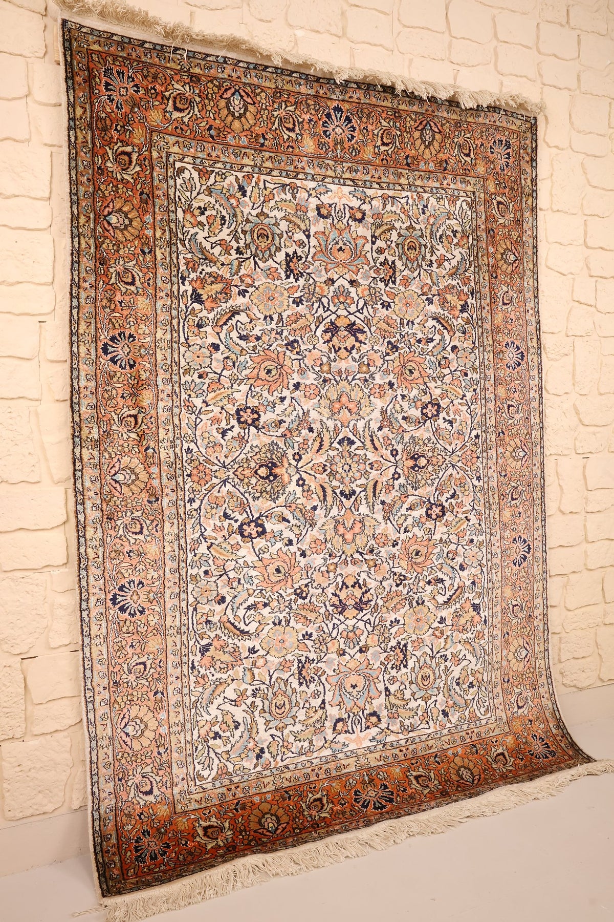 Vue de biais du tapis Cachemire beige et orange, champ sans médaillon central