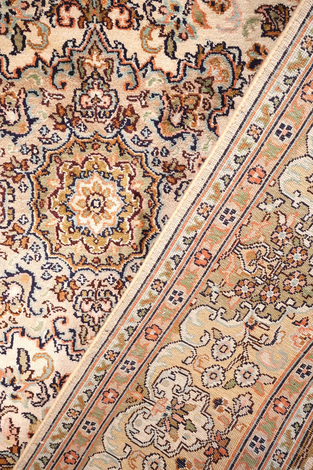 Tapis Cachemire en soie, détail du passage entre champ ivoire et bordure fleurie