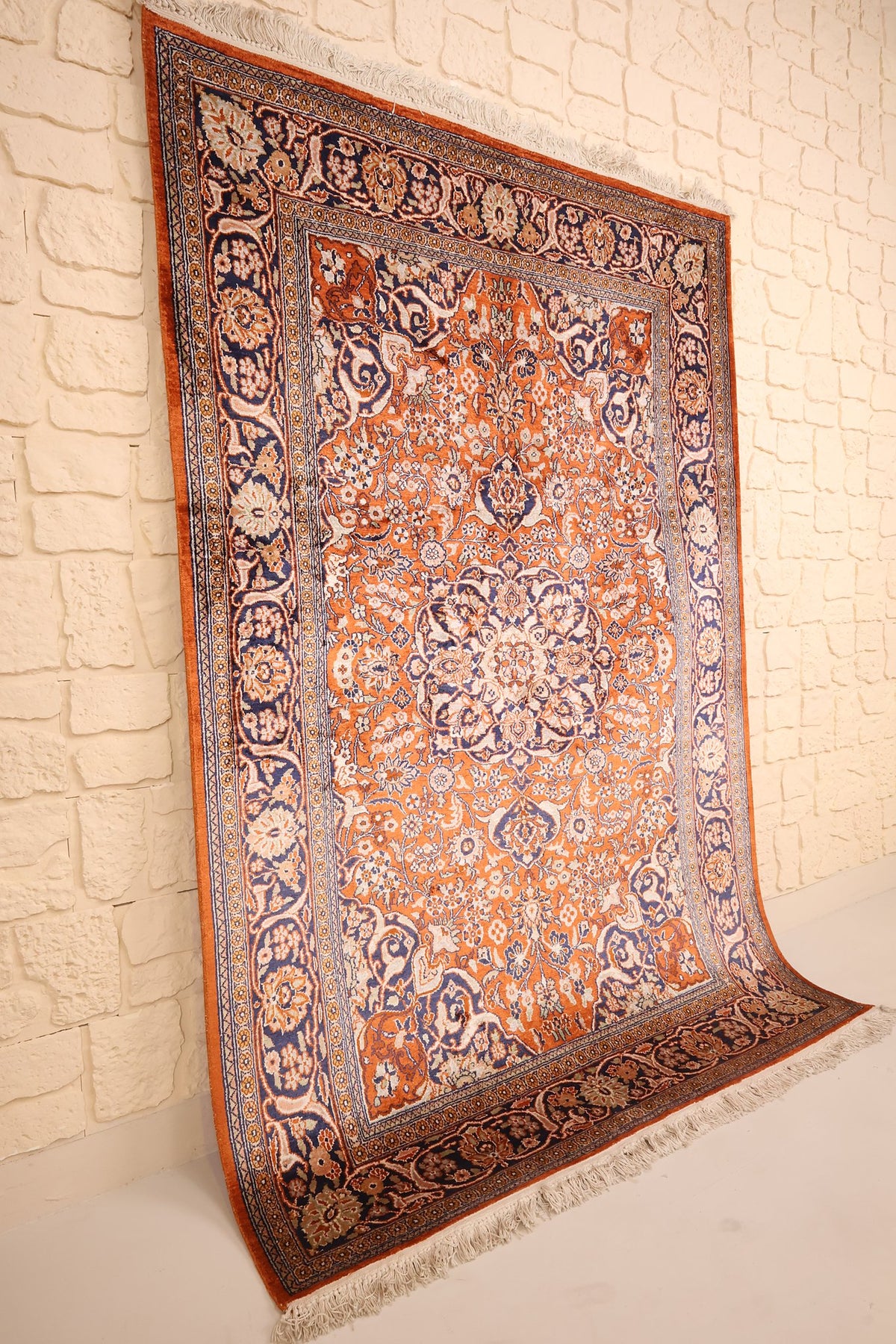 Tapis Cachemire en soie orange et bleu, vue de biais montrant les franges crème
