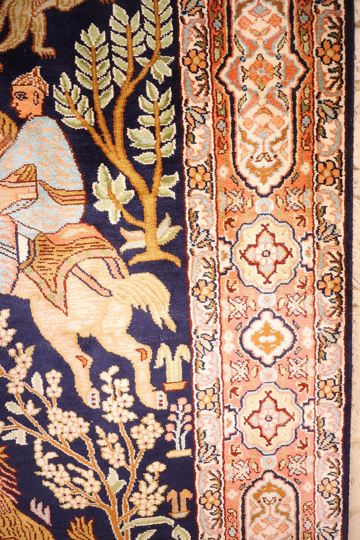 Bordure orangée à cartouches ivoire et arbre fleuri du tapis Cachemire bleu