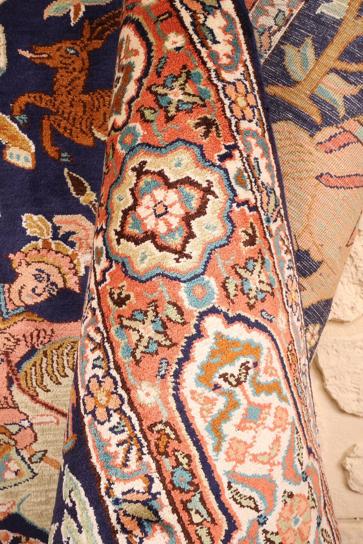 Tapis Cachemire noué main replié, rosace de bordure et champ bleu en gros plan