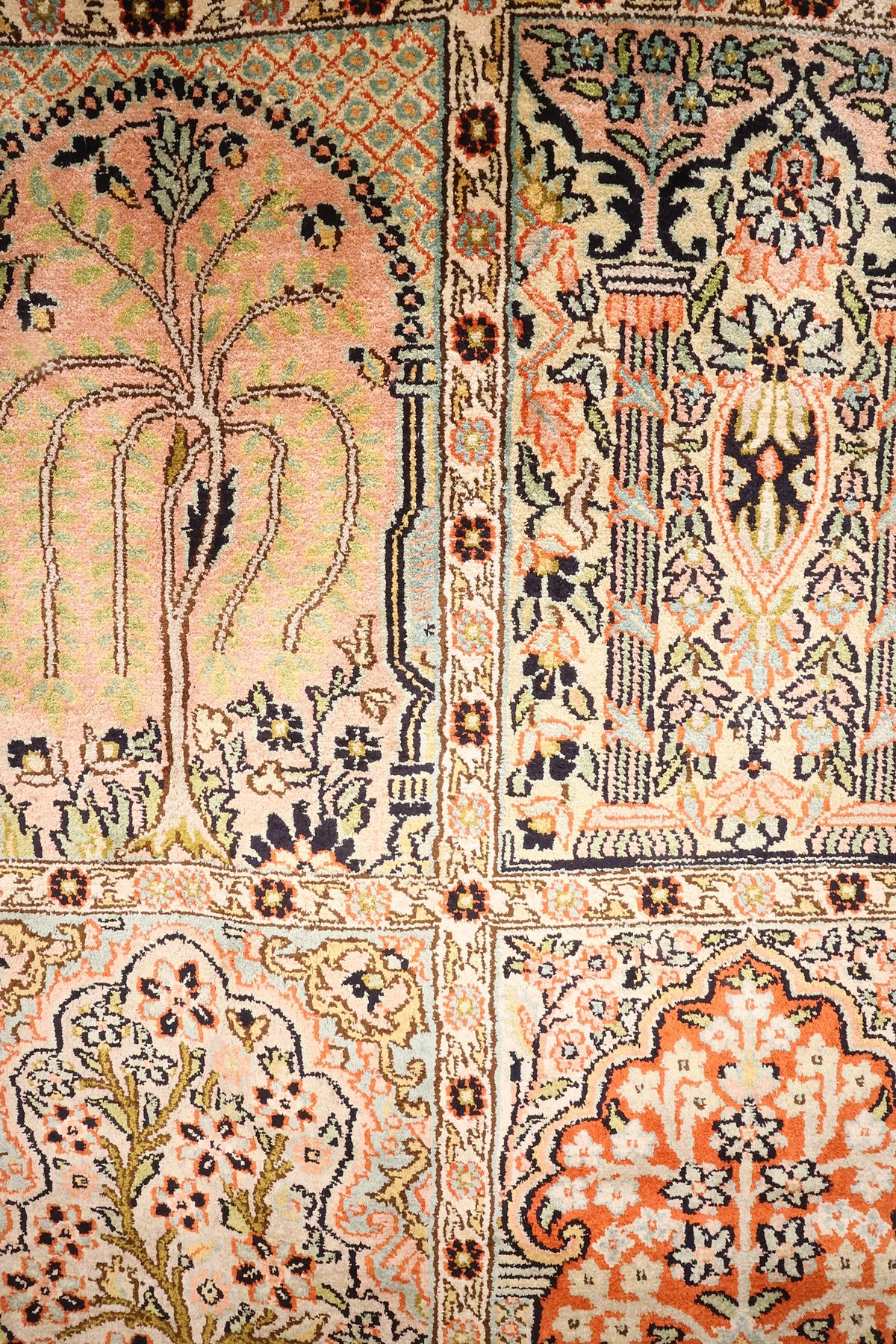 Détail des arbres fleuris du tapis Cachemire sur fonds rose, vert d'eau et orange