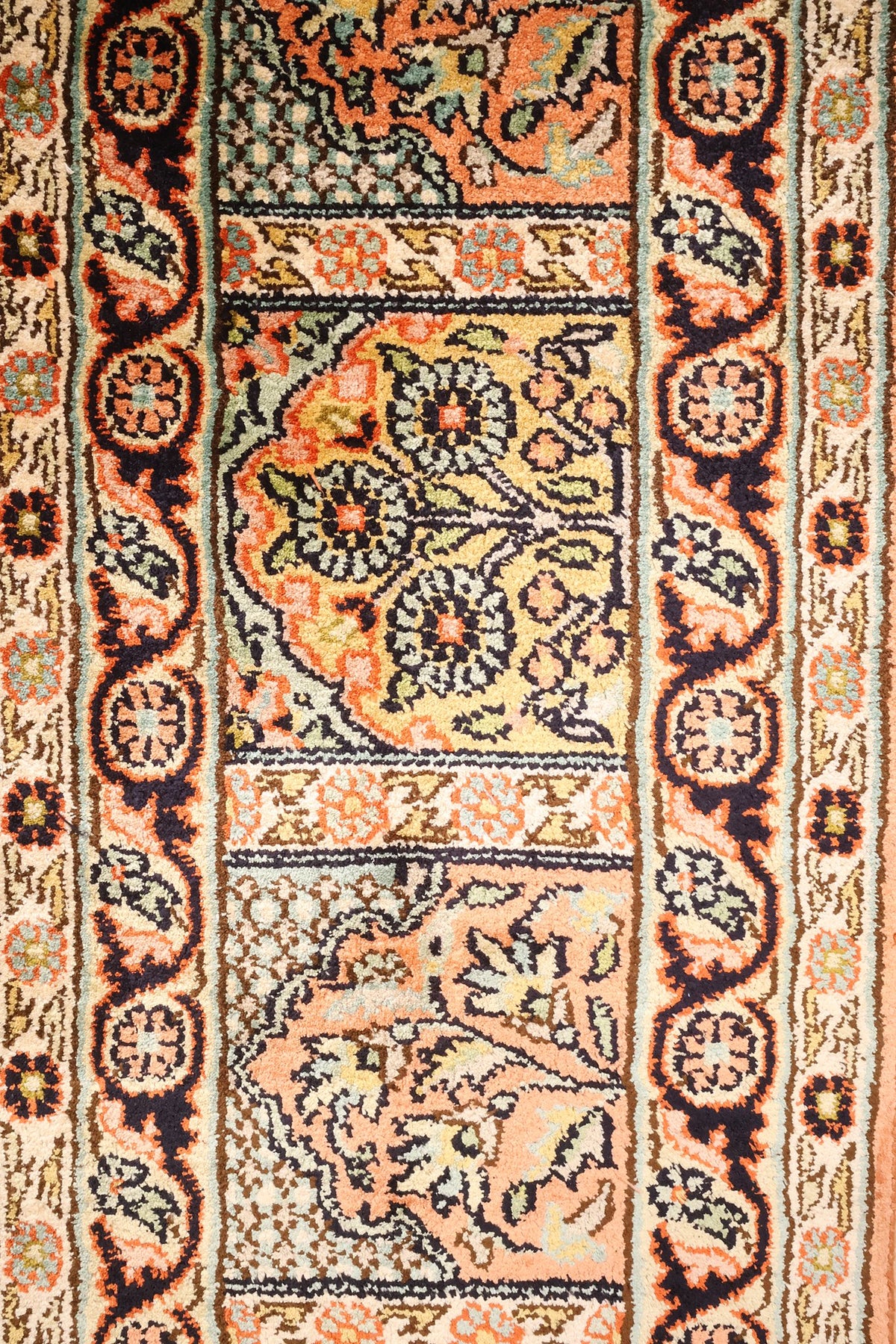 Large bordure sombre à rinceaux et rosettes du tapis Cachemire en soie