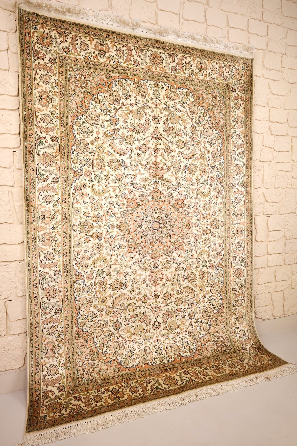 Tapis Cachemire en soie vu de biais, médaillon central saumon et écoinçons aux angles