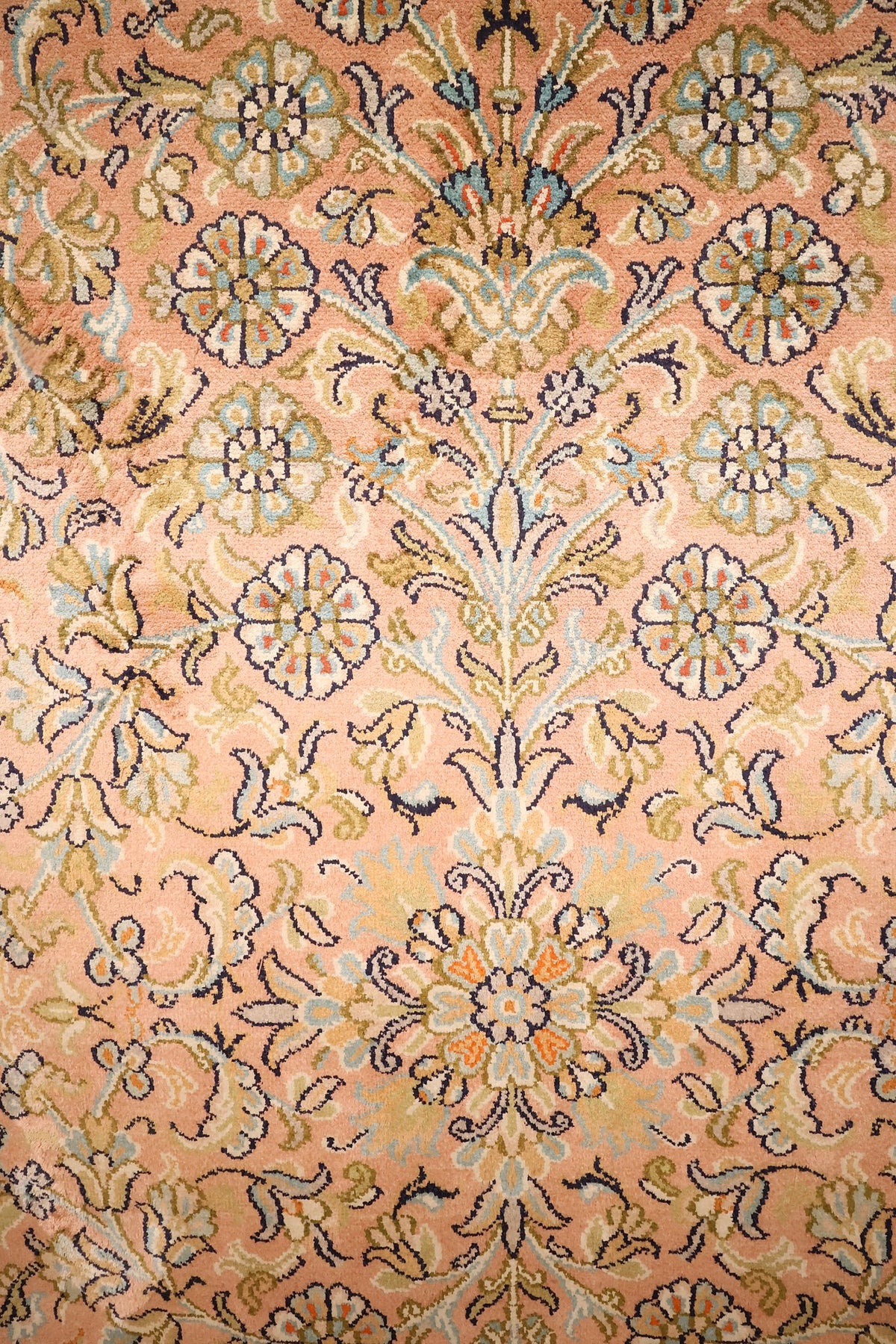 Détail du semis de rosettes et palmettes beige et bleu sur champ rose saumon