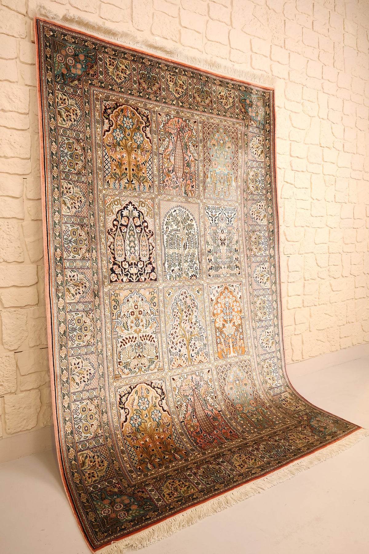 Tapis Cachemire en soie beige, vue de biais montrant les caissons à arcades et les bordures