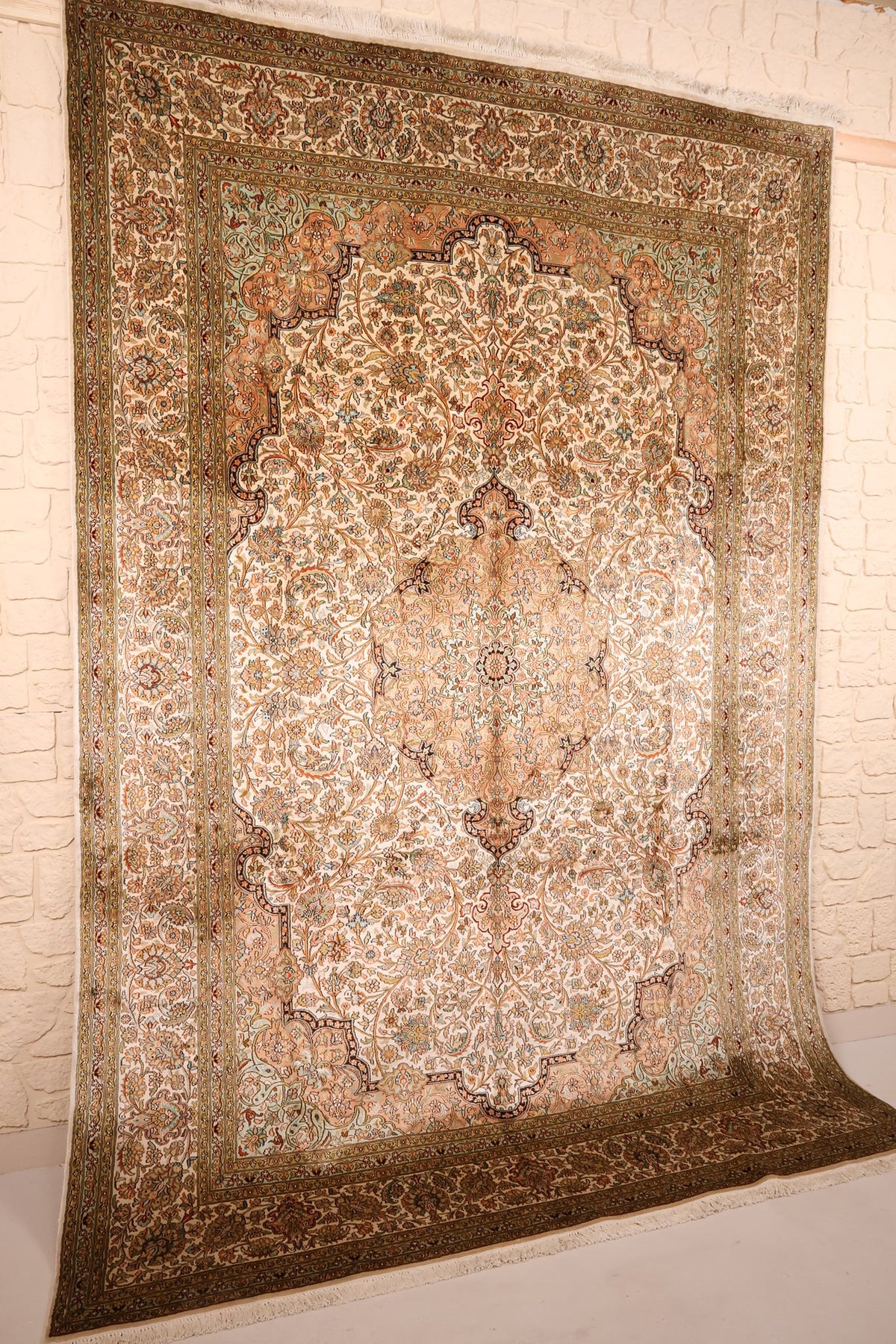 Vue de biais du tapis Cachemire beige et orange, champ fleuri et écoinçons bleu foncé
