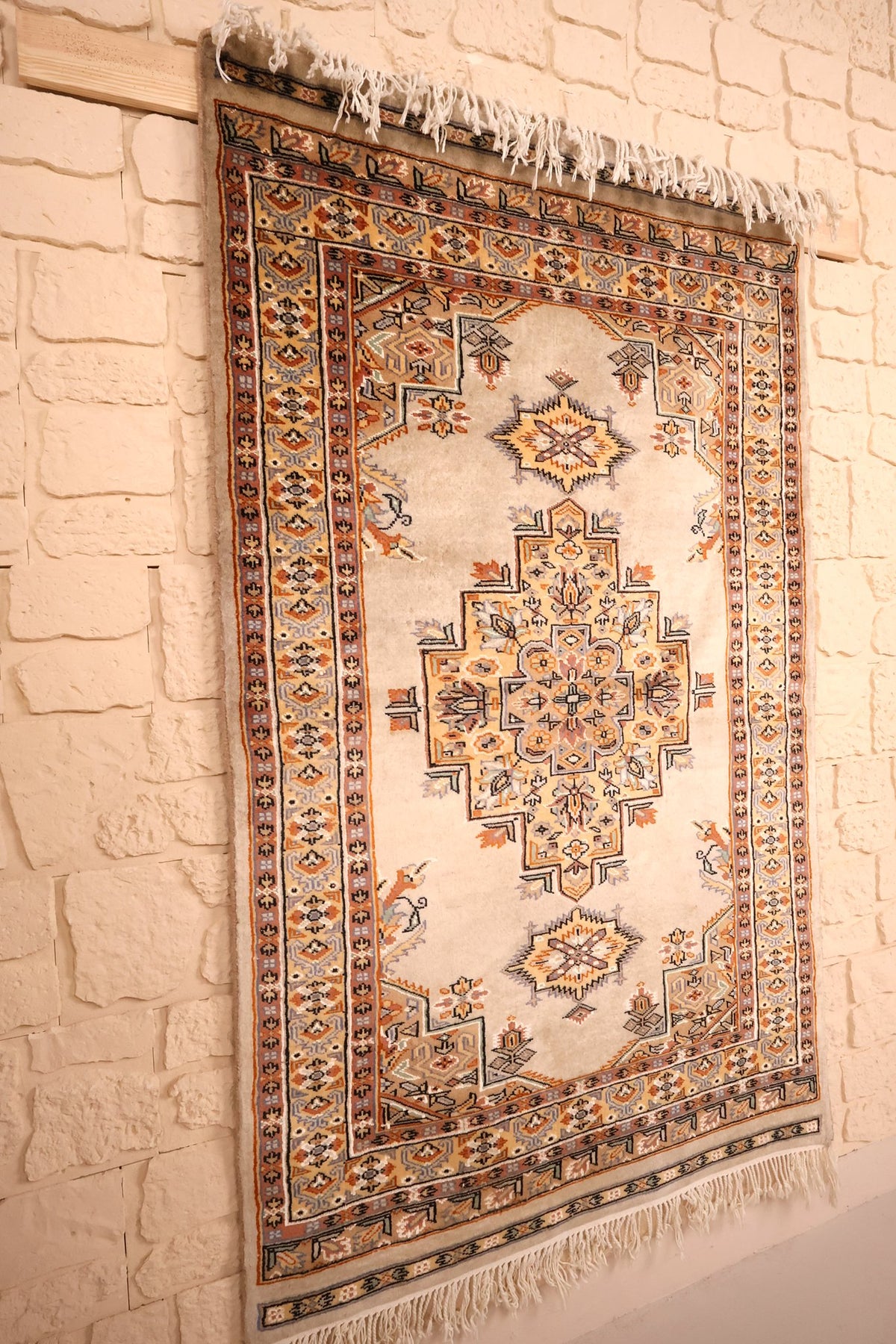 Tapis Caucase en laine noué à la main, vue de biais du champ beige et des bordures