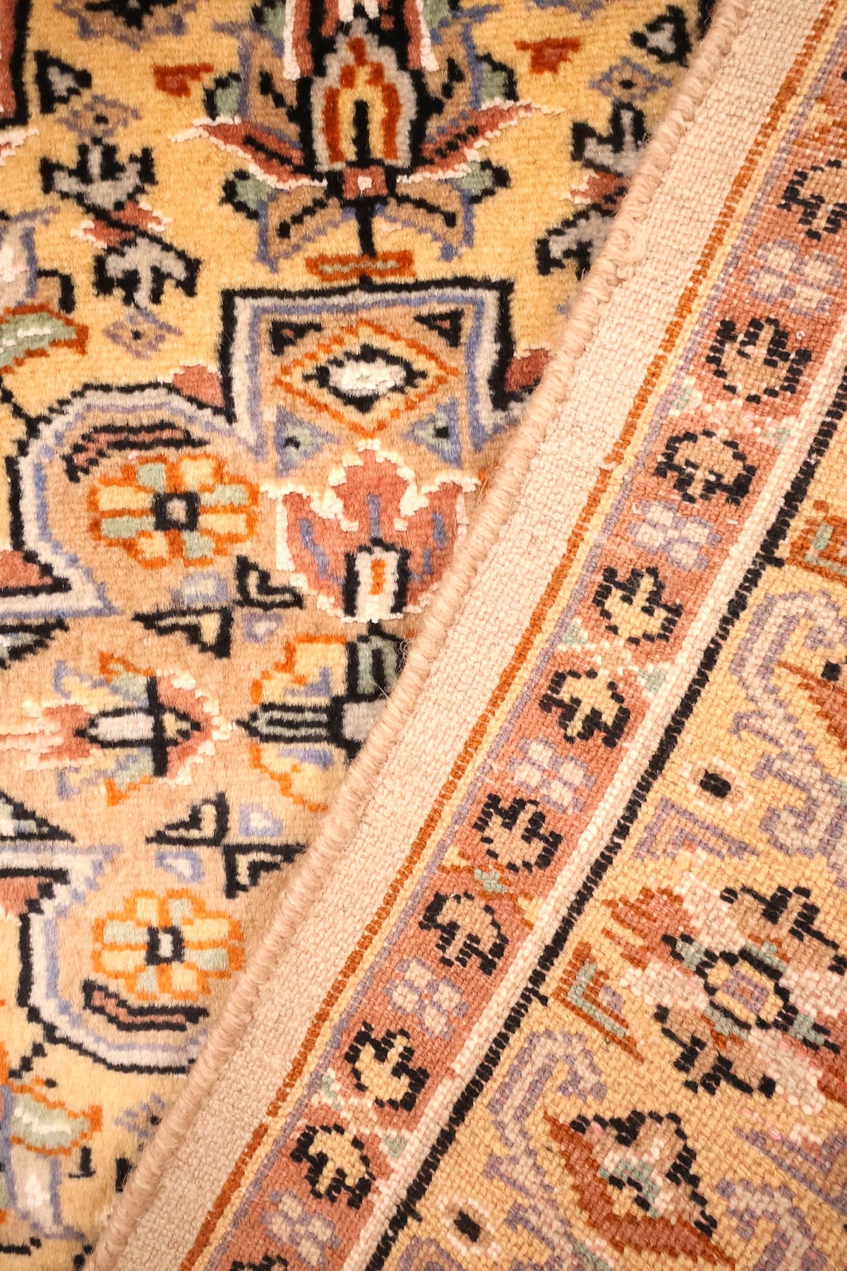 Coin replié du tapis Caucase, laine du champ jaune et envers aux nœuds serrés