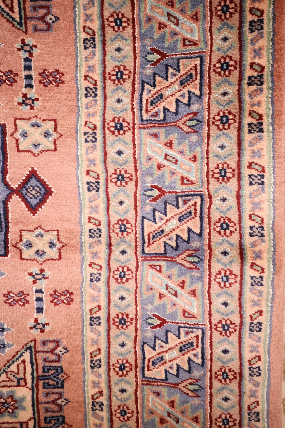 Bordures du tapis Caucase : bande dentelée bleu-gris et contre-bordures à rosettes