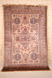 Tapis Caucase rose 186 × 127 cm, vue d'ensemble avec médaillon central et franges écrues