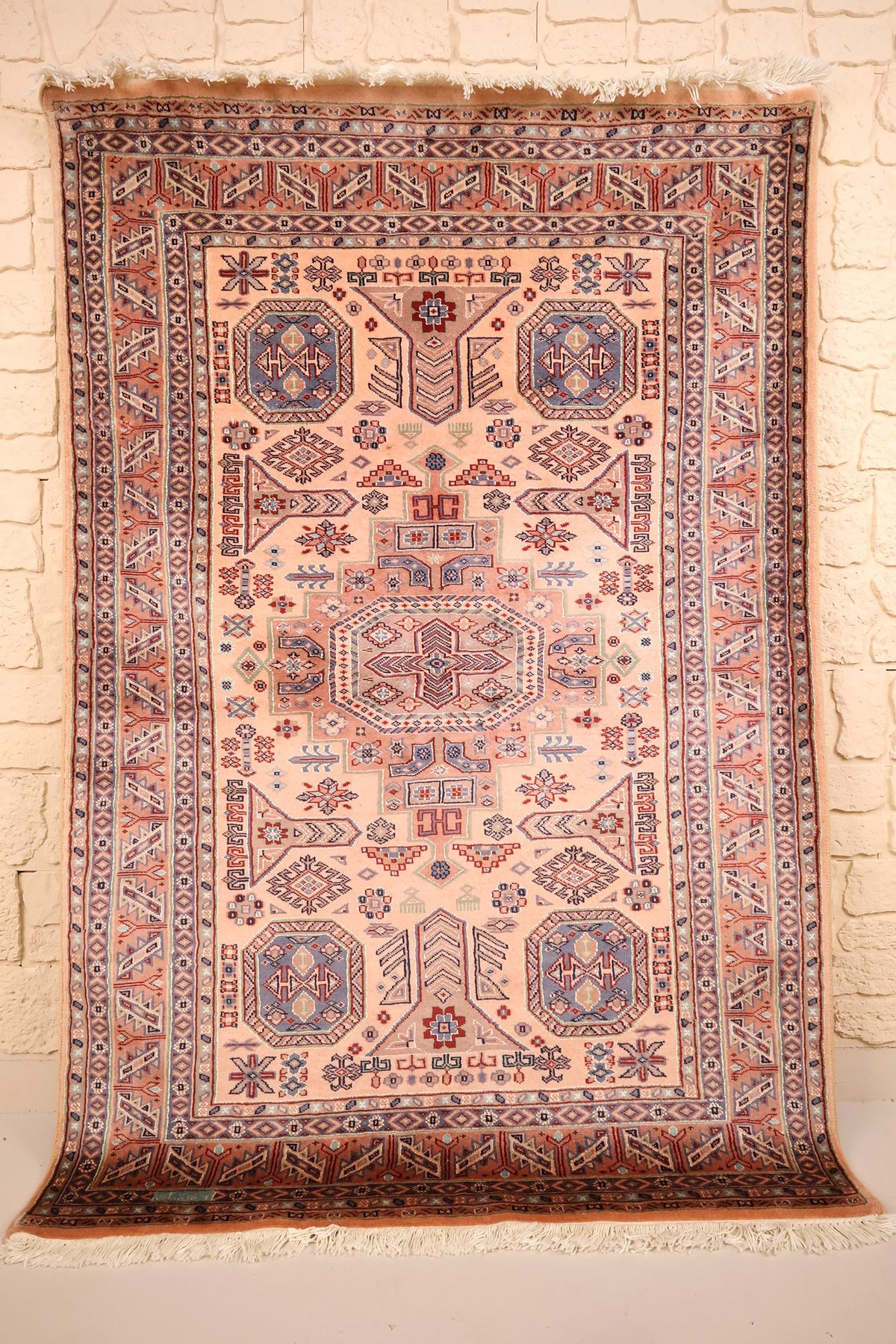 Tapis Caucase rose 186 × 127 cm, vue d'ensemble avec médaillon central et franges écrues