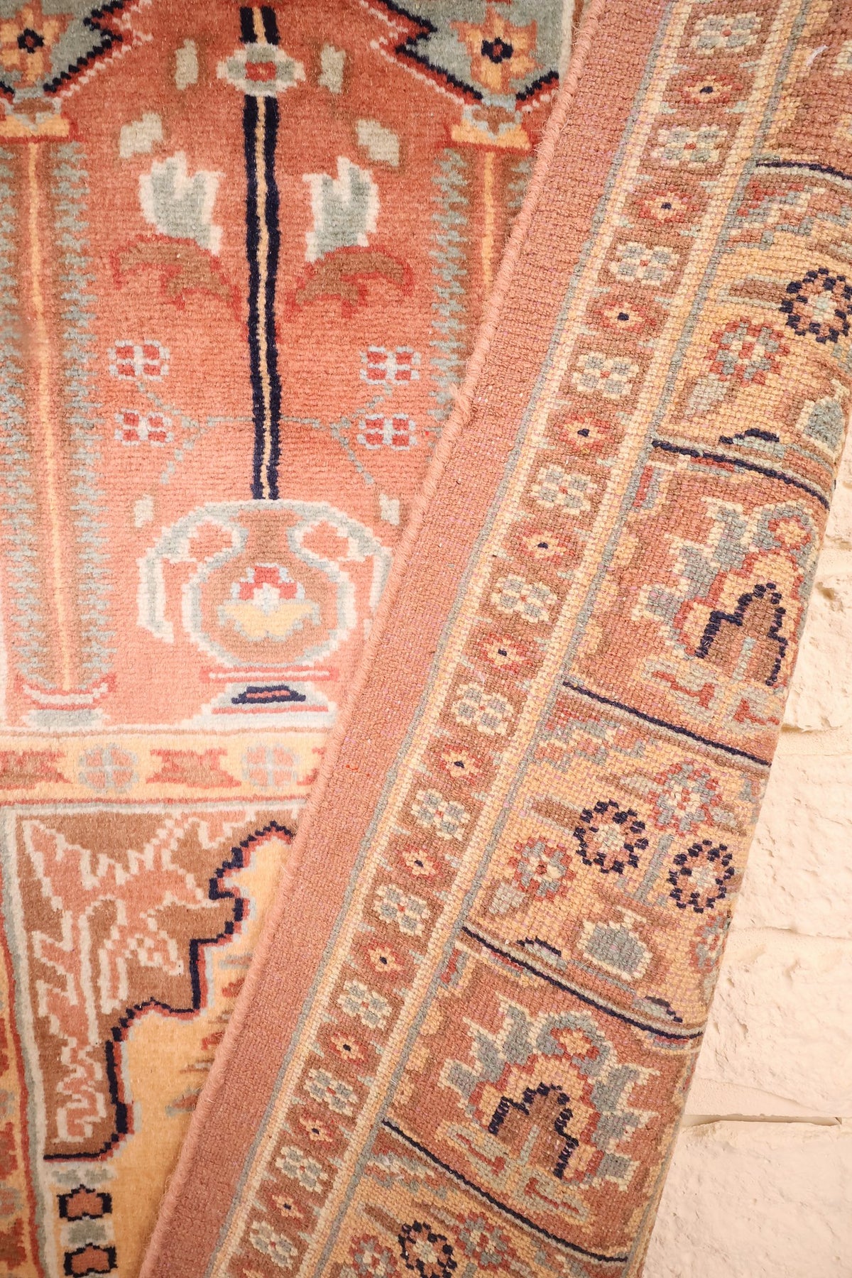 Coin replié du tapis Caucase 187 × 121 cm, bordure et bouquet stylisé