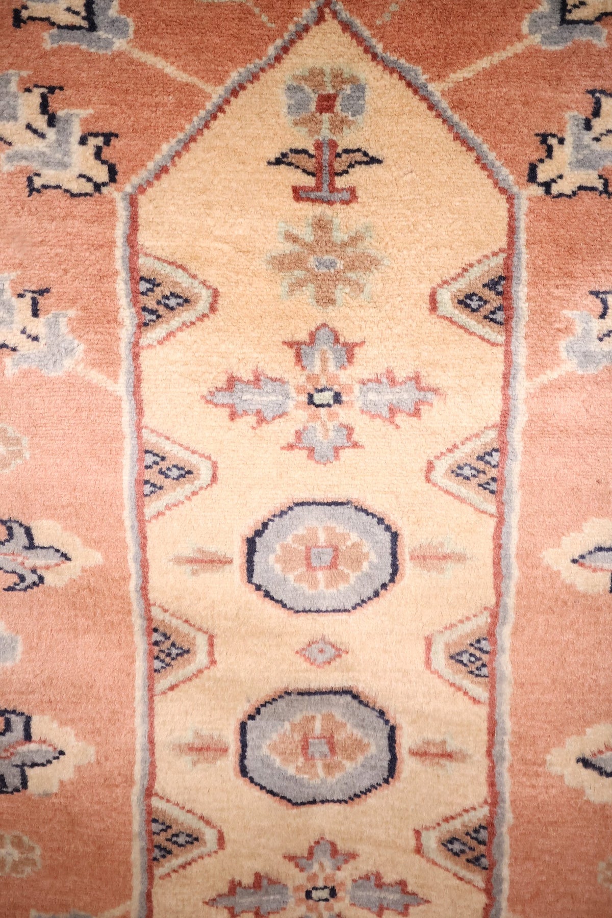 Détail du médaillon central beige et des octogones bleu-gris du tapis Caucase