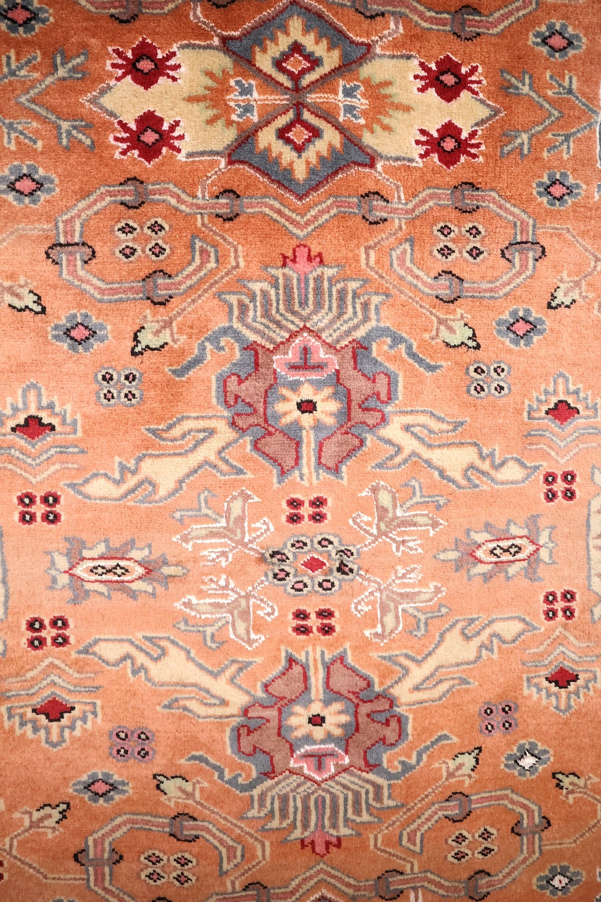 Détail du champ orange saumon : palmettes et rosettes anguleuses bleu-gris et ivoire