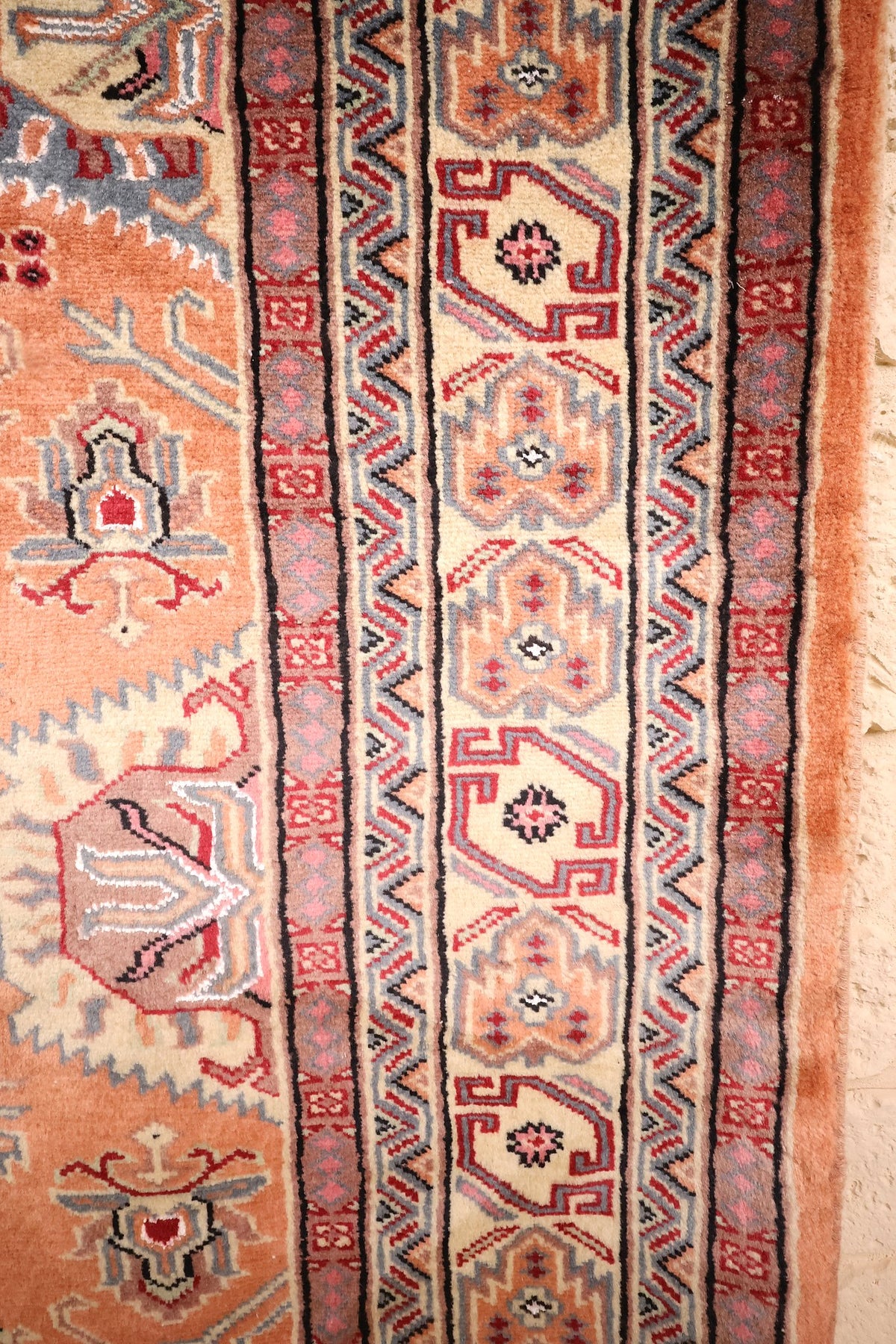 Bordure ivoire à motifs crochetés et contre-bordures gris-bleu du tapis Caucase