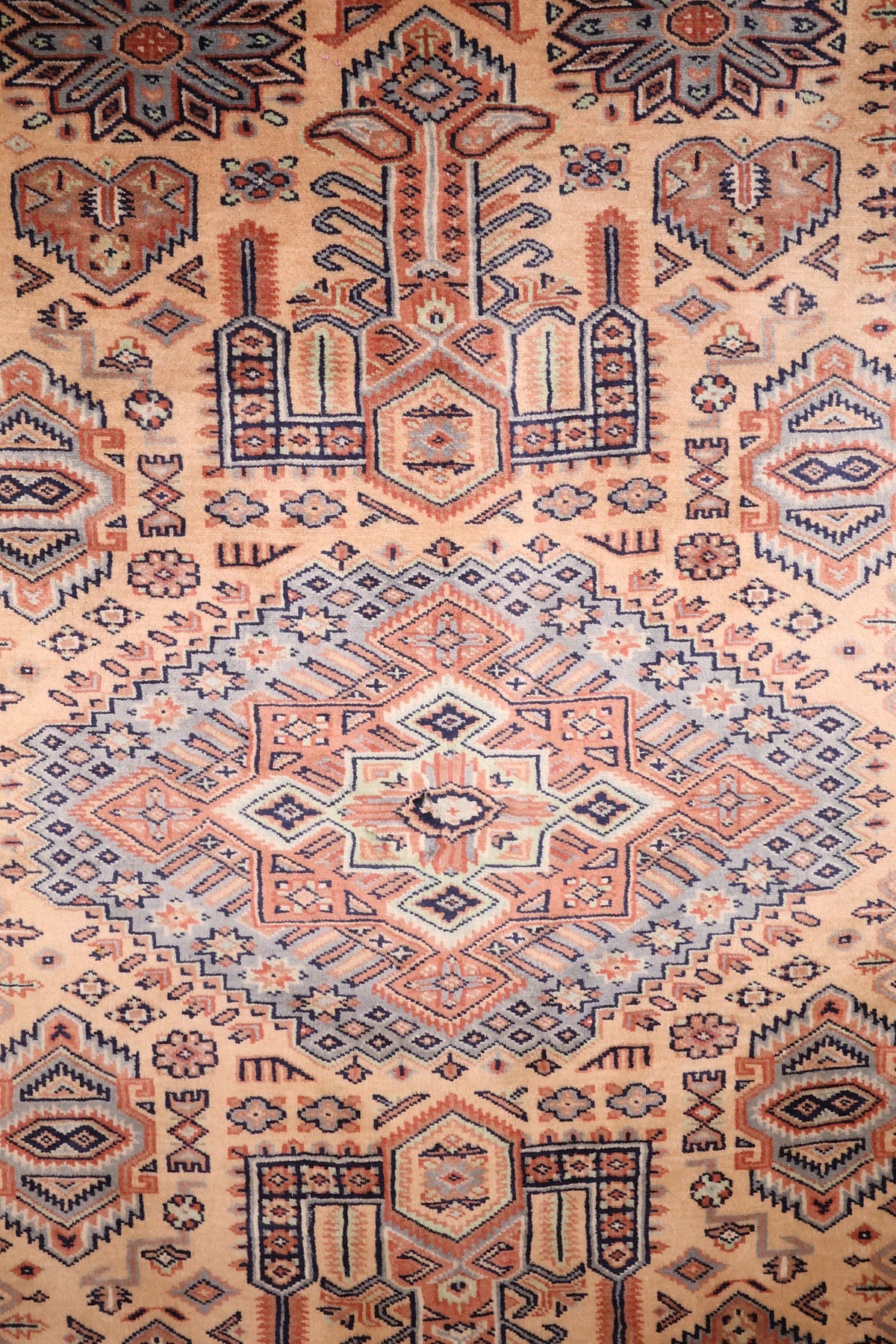 Détail du médaillon en losange cranté et des rosaces étoilées du tapis Caucase