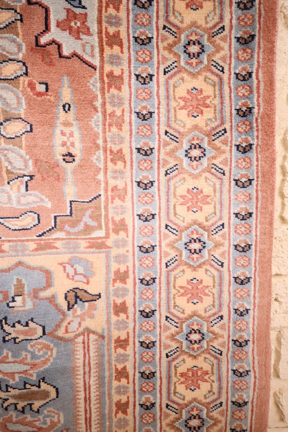 Bordure beige à rosaces et étoiles bleues, contre-bordures fleuries du tapis rose