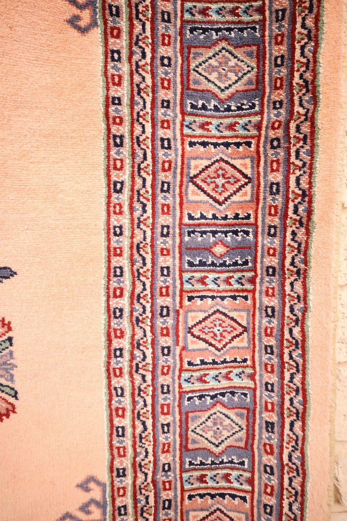 Bordure à cartouches losangés et contre-bordures étroites du tapis Caucase rose