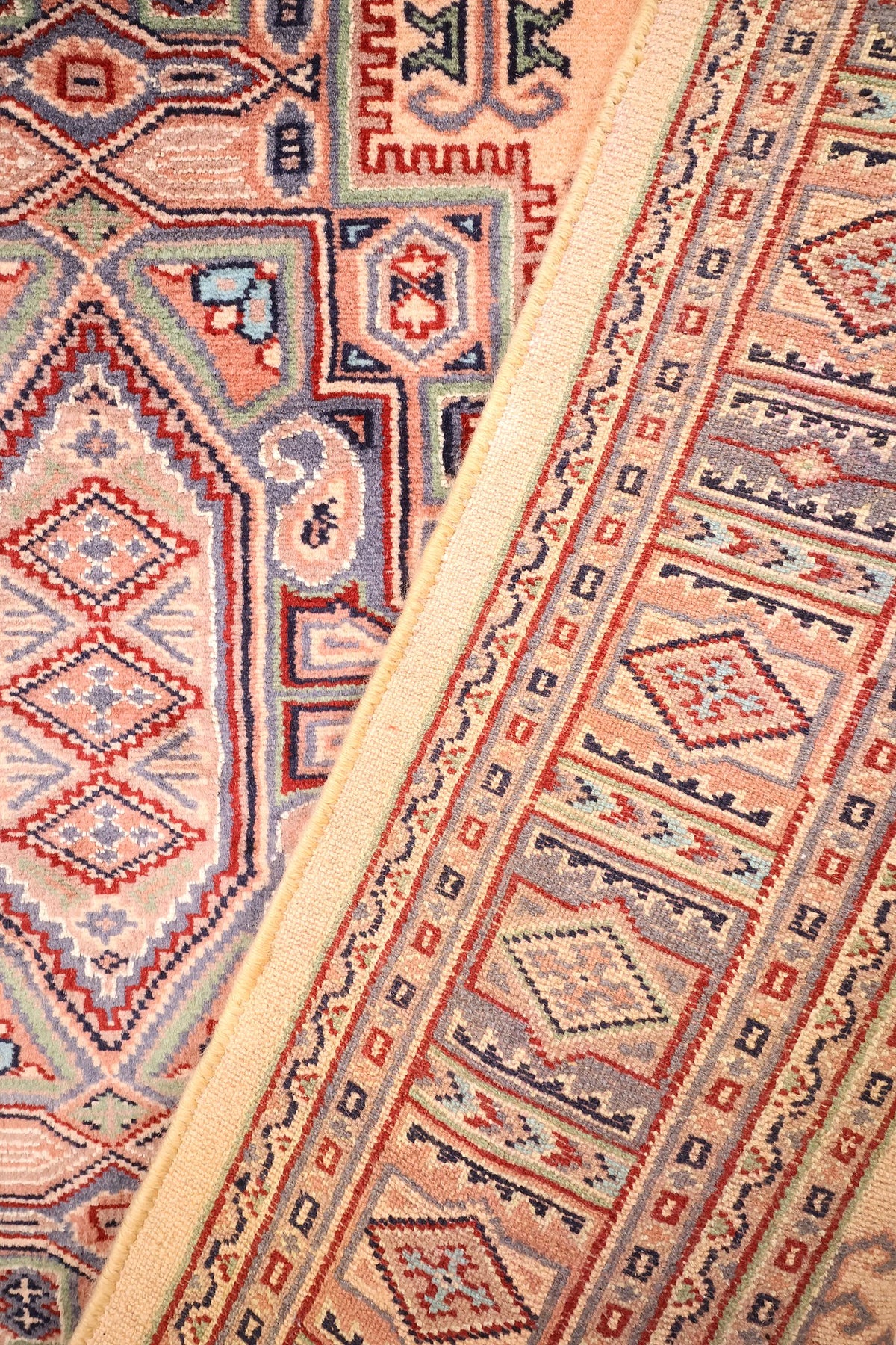 Coin replié du tapis Caucase, écoinçons en escalier et boteh stylisés