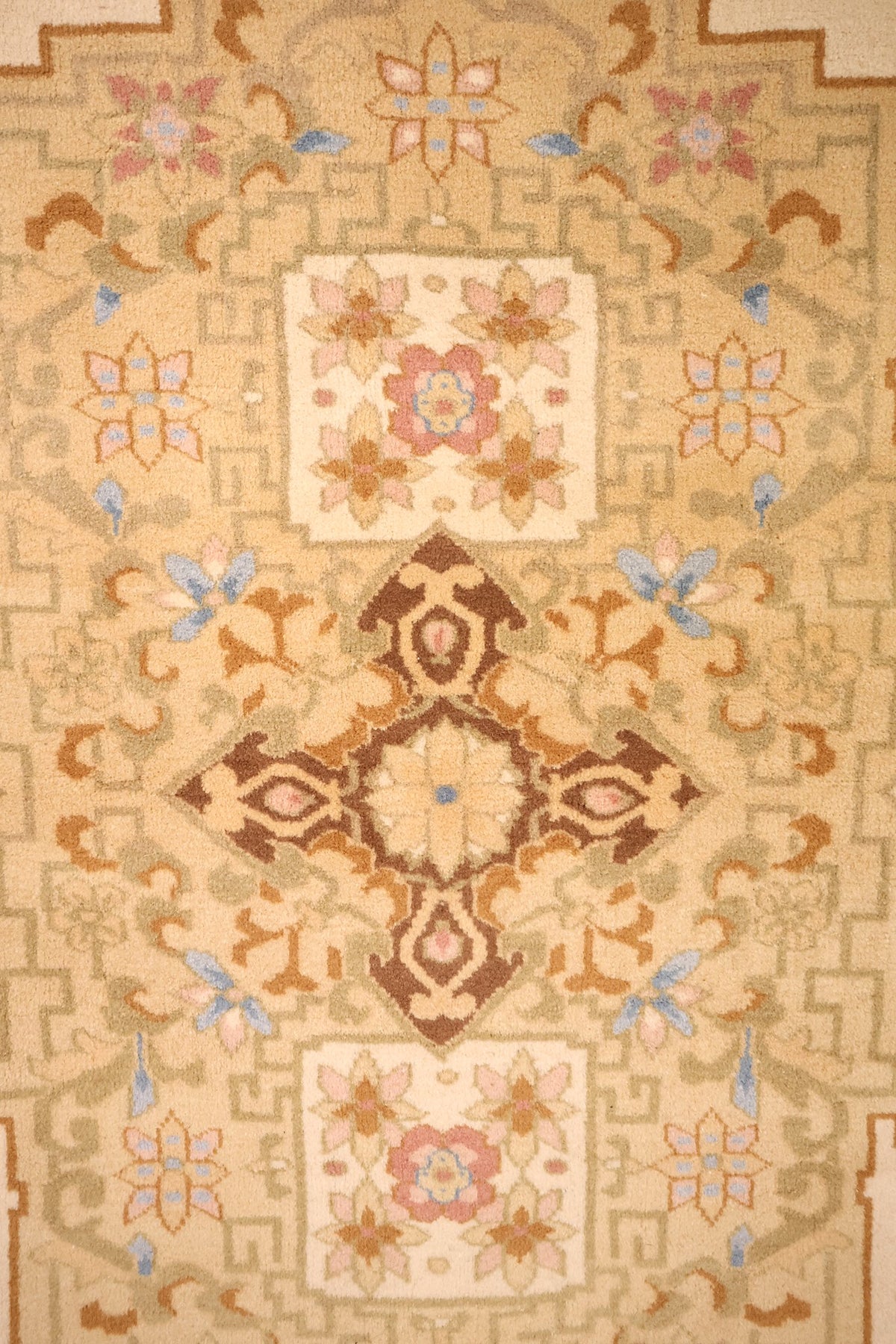 Détail du médaillon losangé brun et rose du tapis Chinois beige
