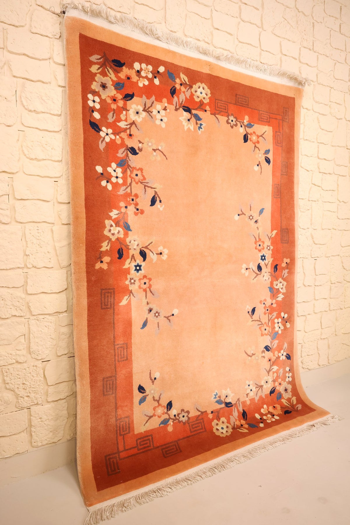 Tapis Chinois en laine noué main, vue de biais montrant la bordure rouge-brique