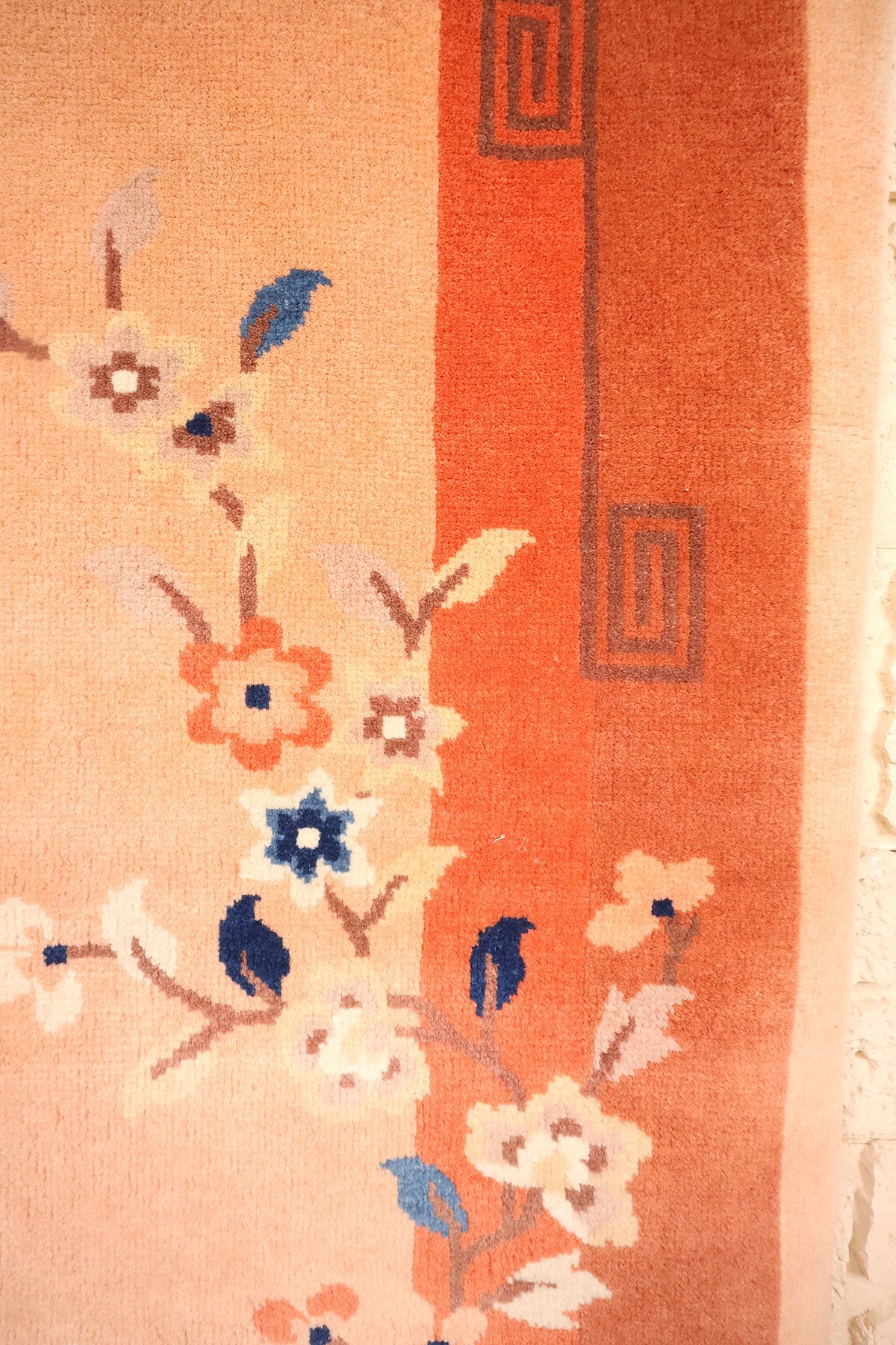 Détail des fleurs blanches et bleues et des grecques grises du tapis Chinois