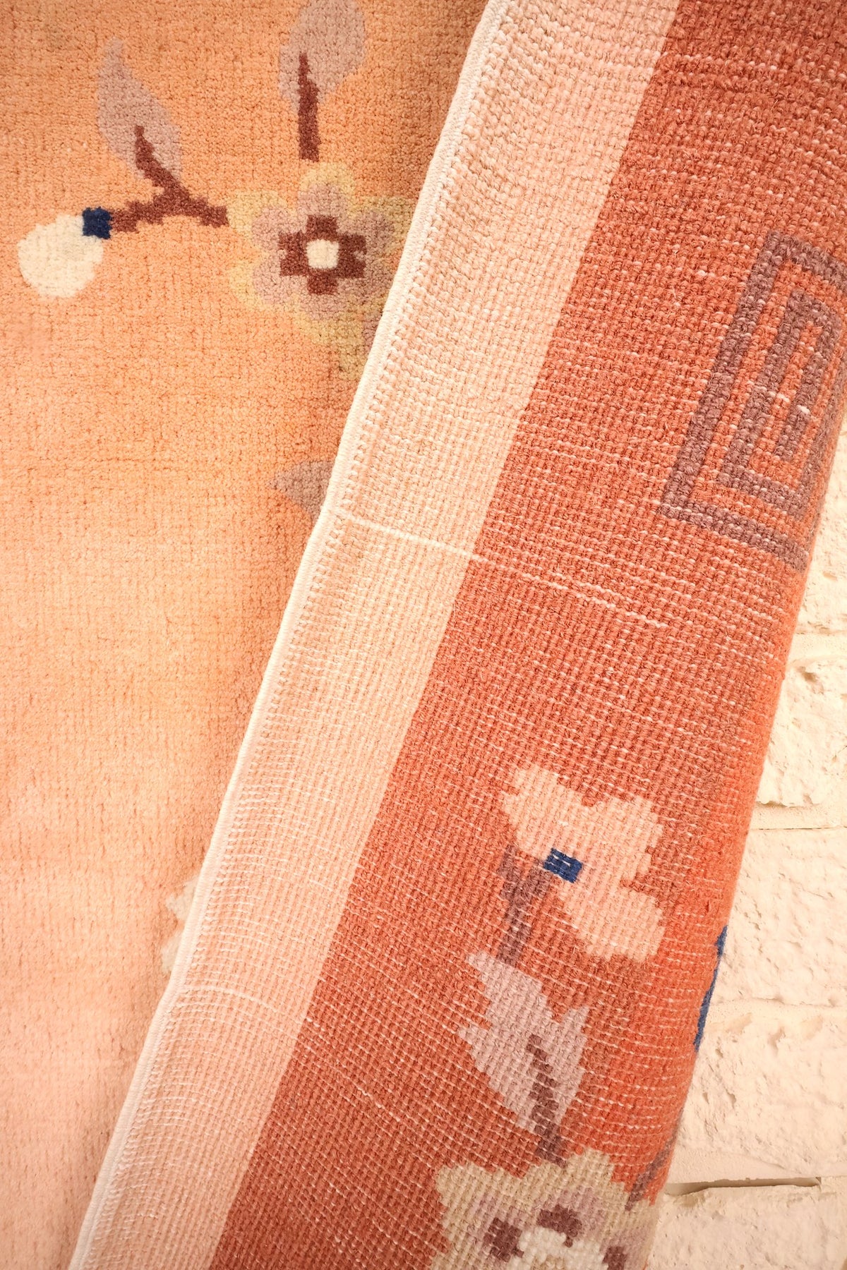 Envers du tapis Chinois en laine, nœuds serrés et grecque de bordure visibles