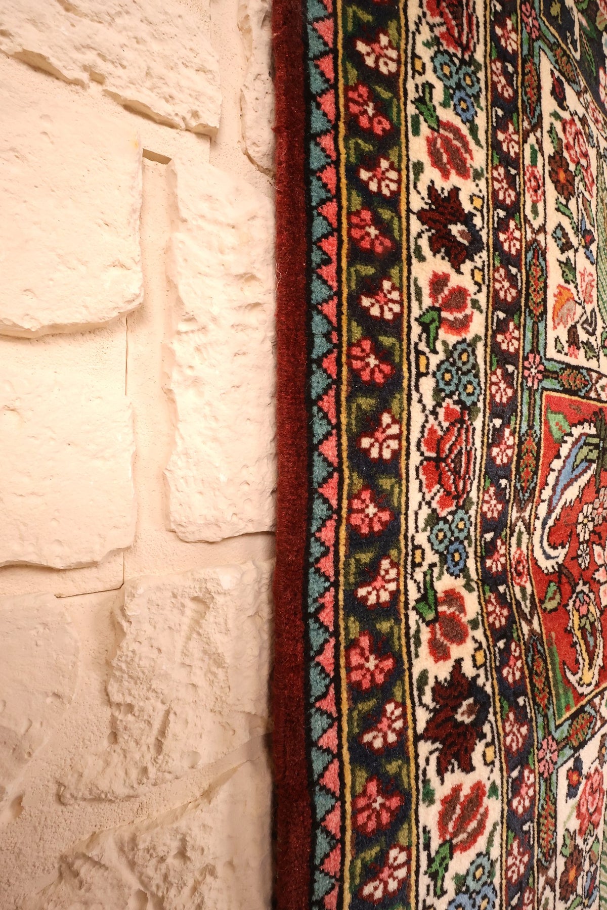 Bord latéral du tapis Djahad noué main, bordure fleurie le long du mur