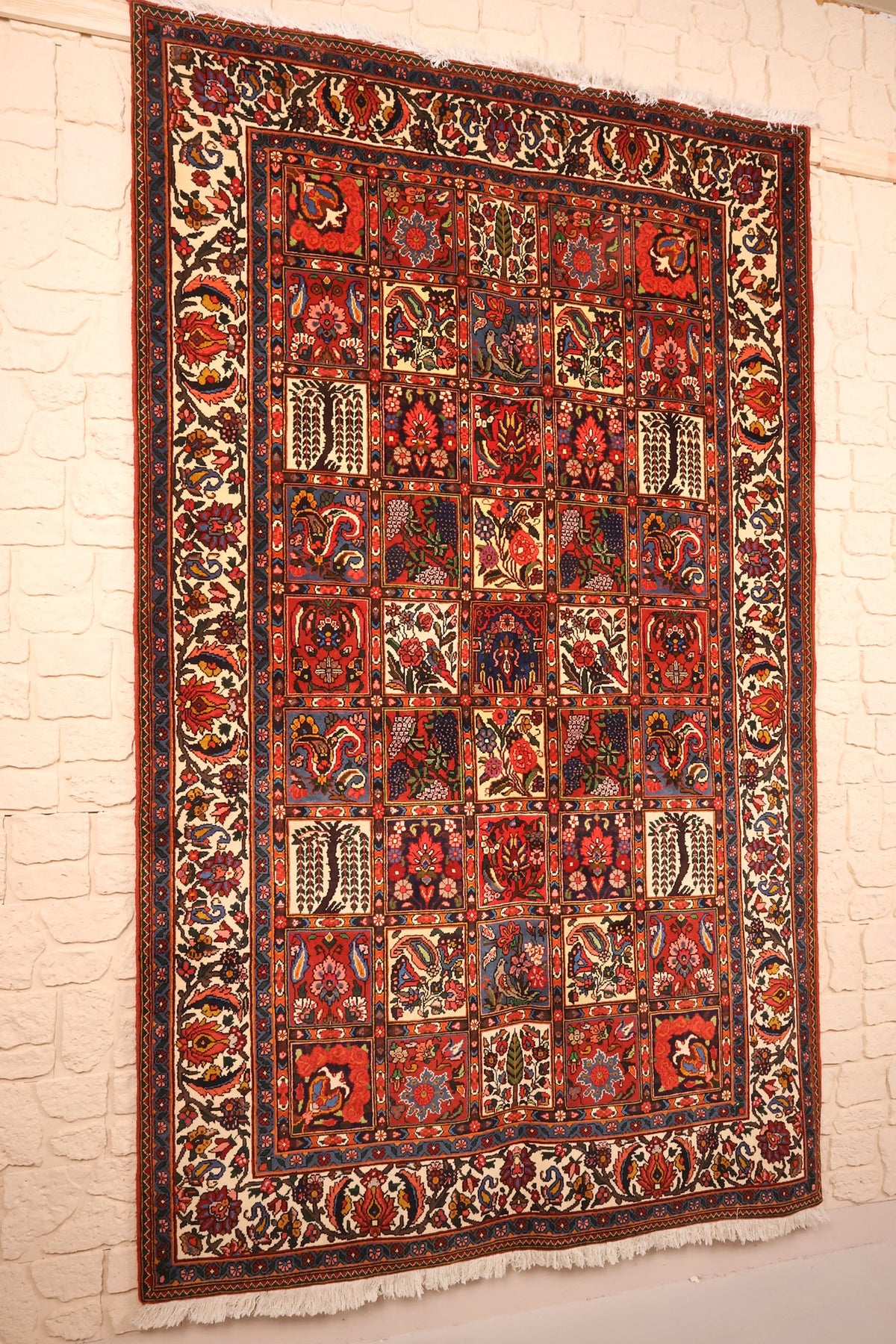 Tapis Djahad en laine noué main, vue de biais montrant la bordure ivoire à palmettes