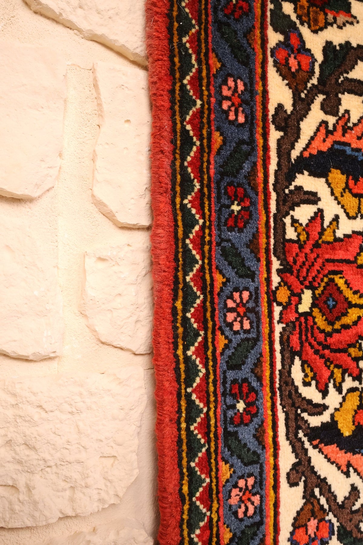 Lisière rouge du tapis Djahad en laine, contre-bordures bleues à petites fleurs
