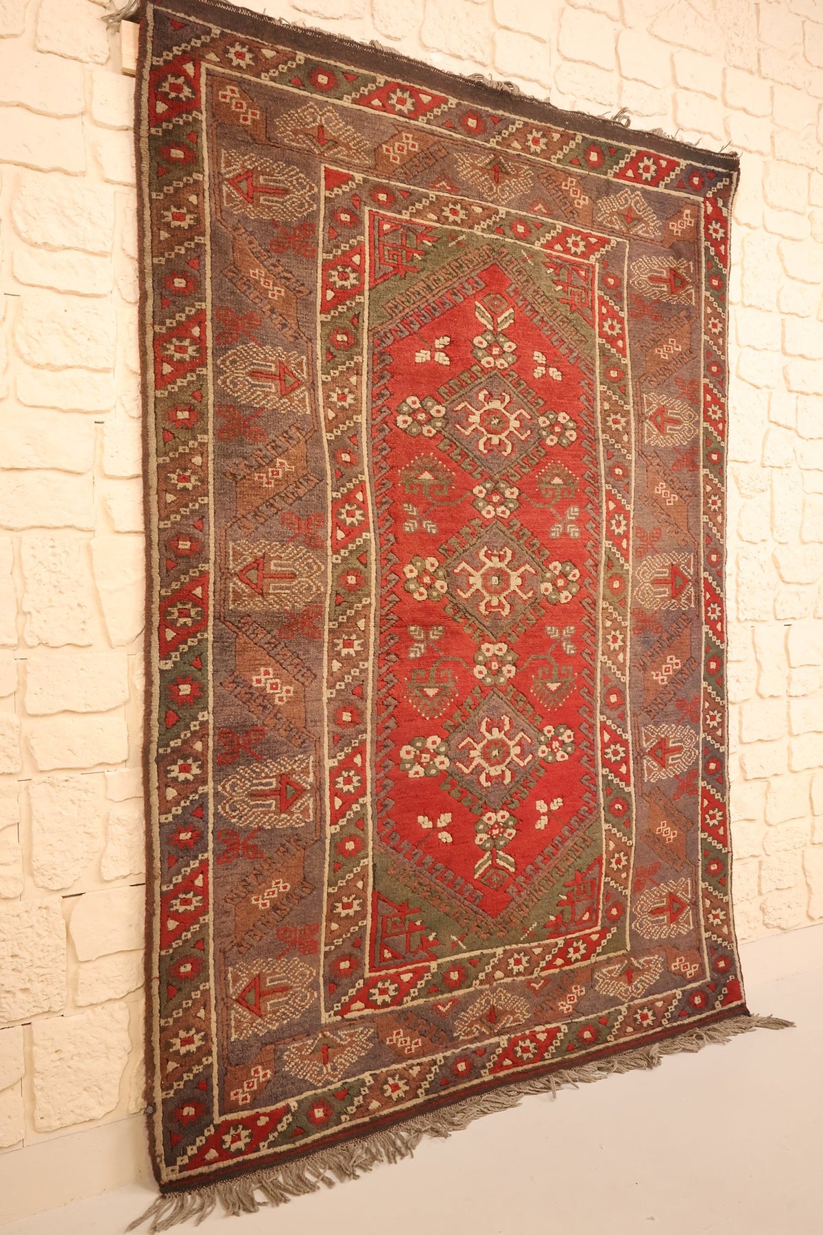 Tapis Dodgem Alti rectangulaire rouge et marron vu de biais, bordures multiples visibles