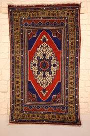 Tapis Dodgem Alti bleu et rouge 180 × 100 cm, vue d'ensemble avec médaillon losangé ivoire
