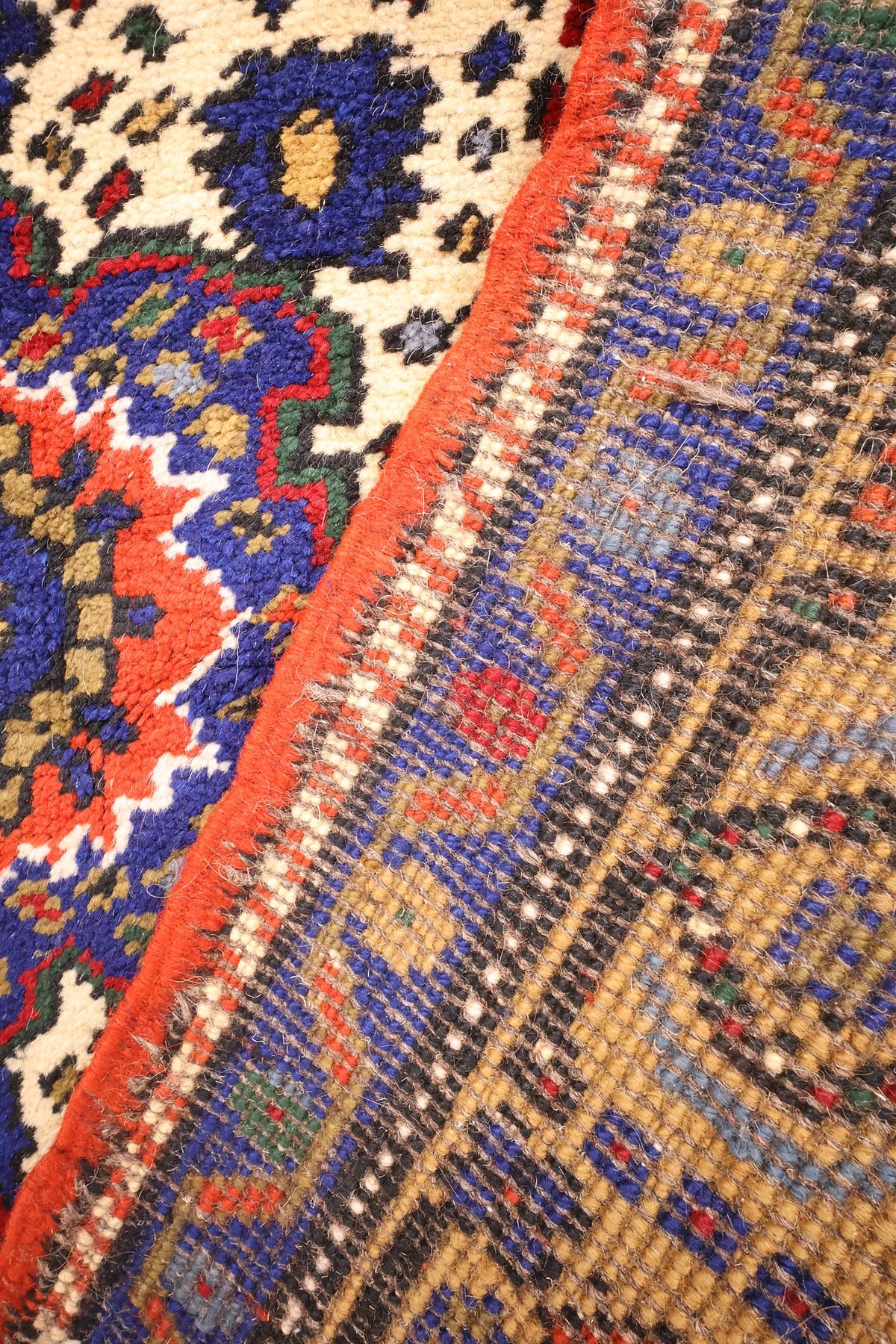 Envers du tapis Dodgem Alti 180 × 100 cm, nœuds et couleurs bleu, rouge et beige visibles