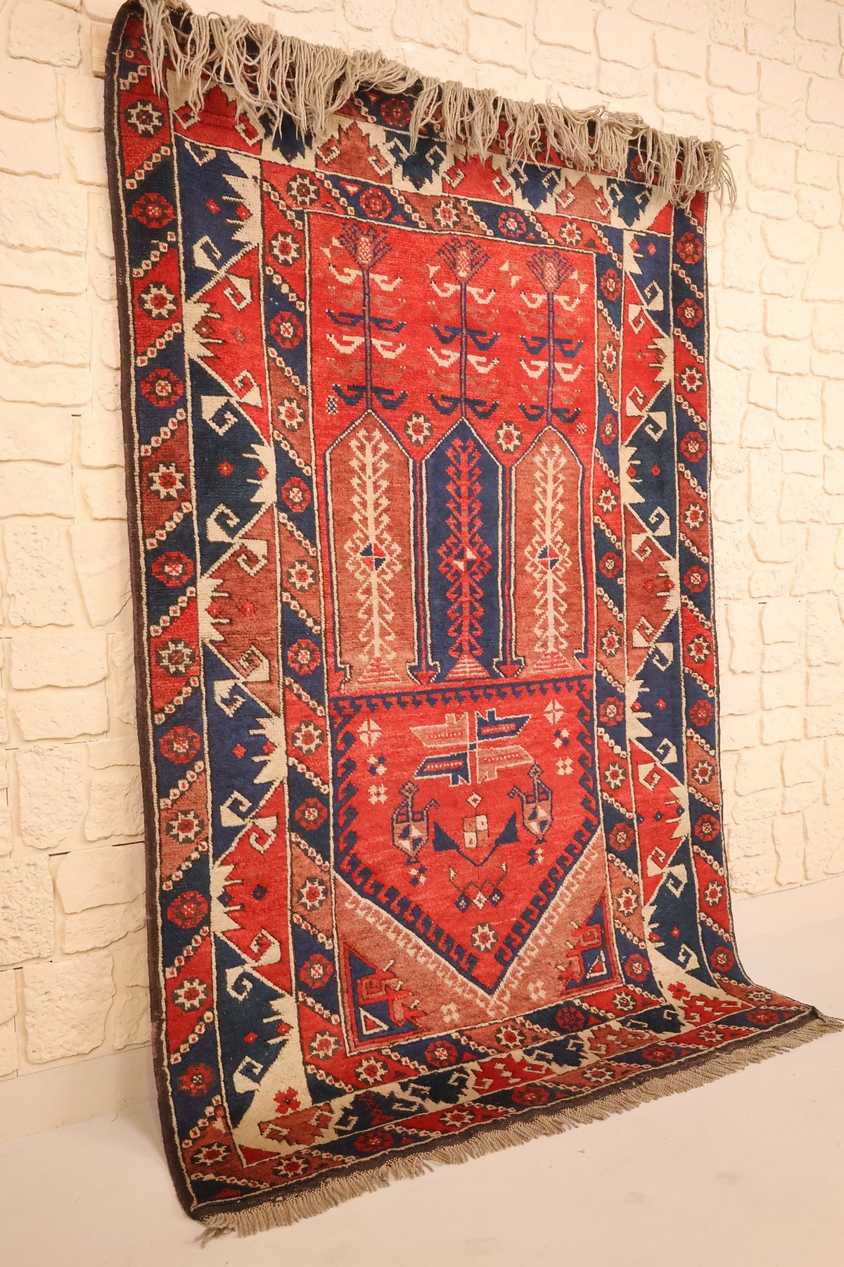 Tapis Dodgem Alti rectangulaire à dominante rouge, vue de biais montrant les bordures bleu nuit