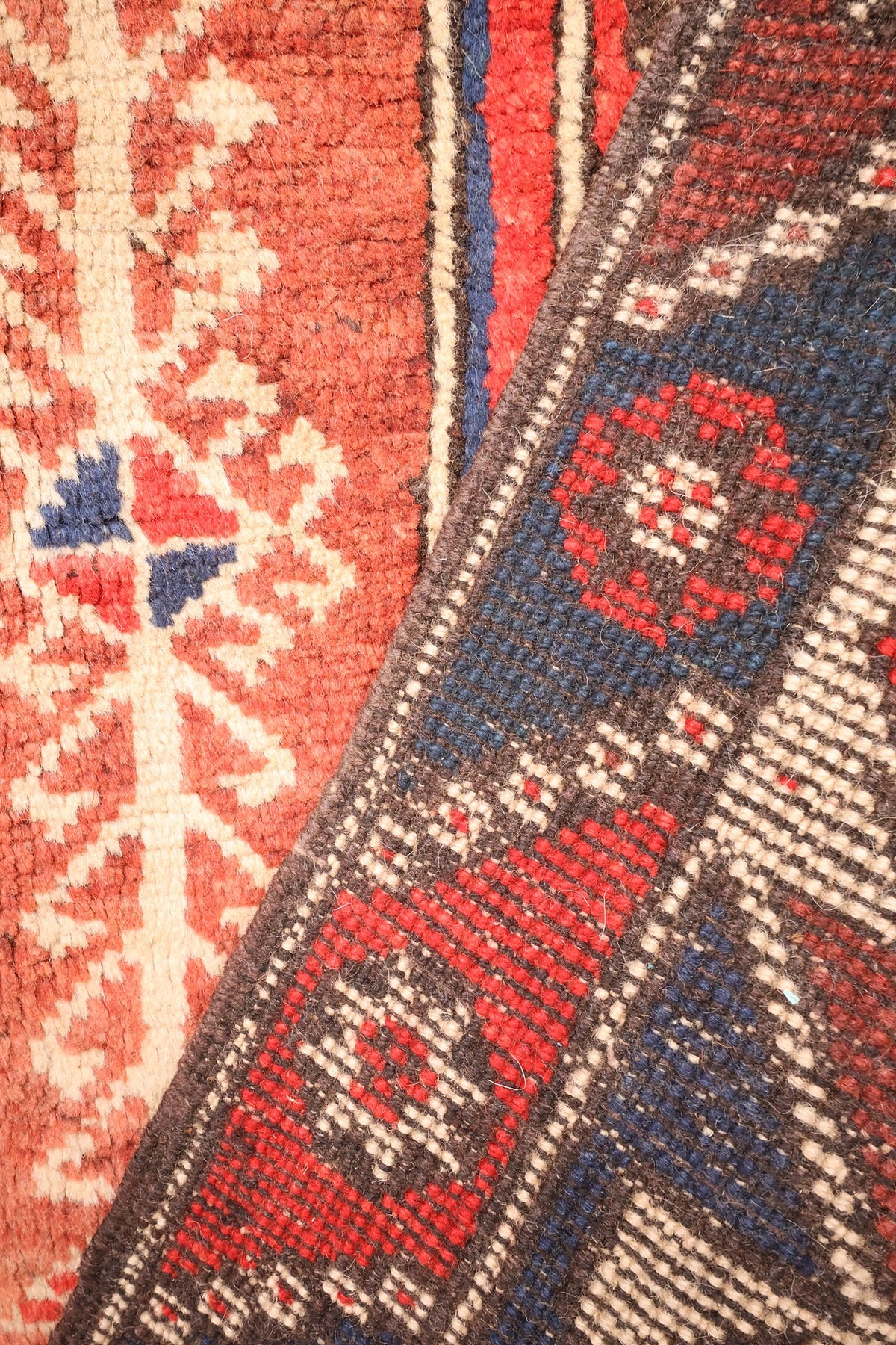 Envers du tapis Dodgem Alti, nœuds visibles et reprise des rouges et bleus au dos