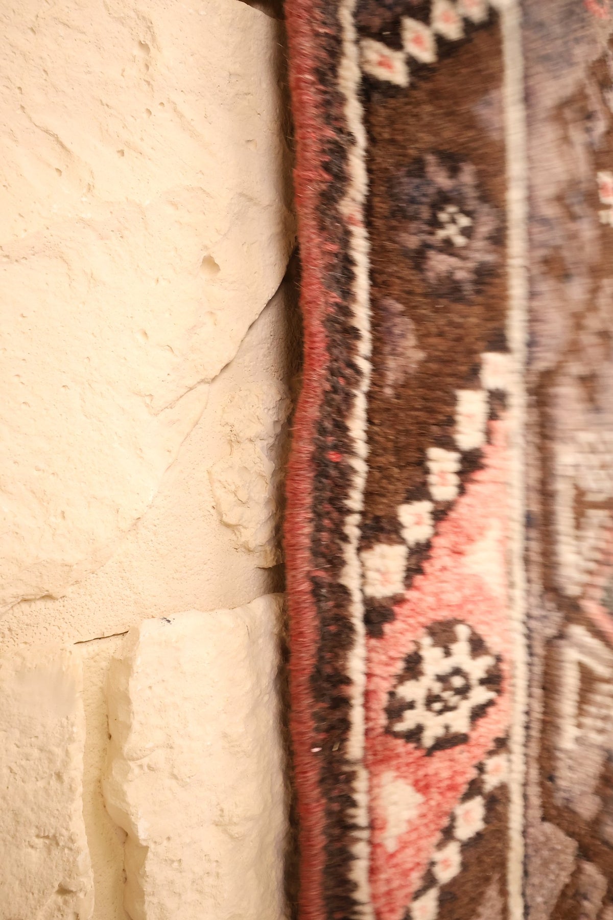 Lisière du tapis Dodgem Alti, bordure marron à rosettes crème vue de profil