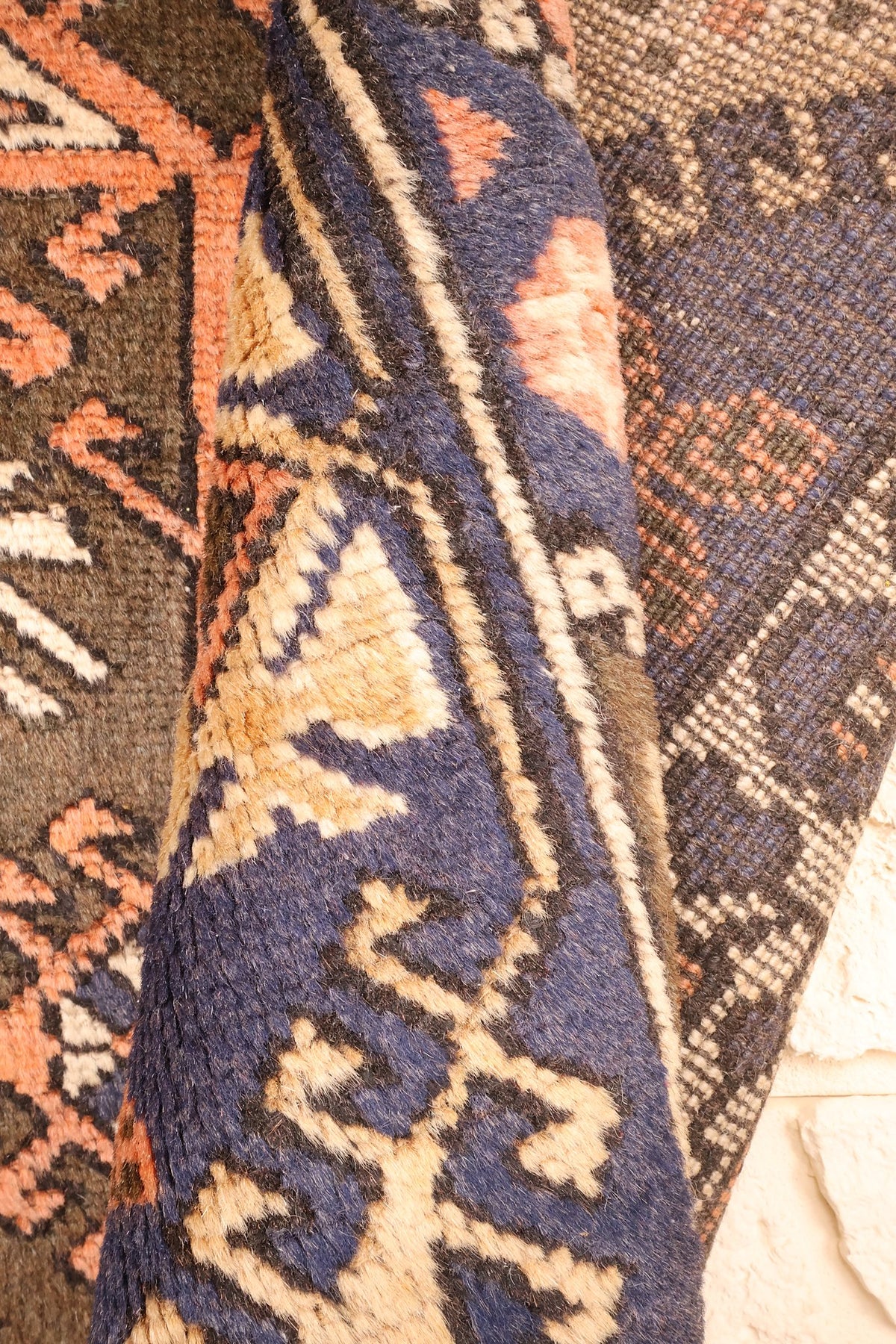 Envers du tapis Dodgem Alti, nœuds visibles sur la bordure bleue et le champ brun