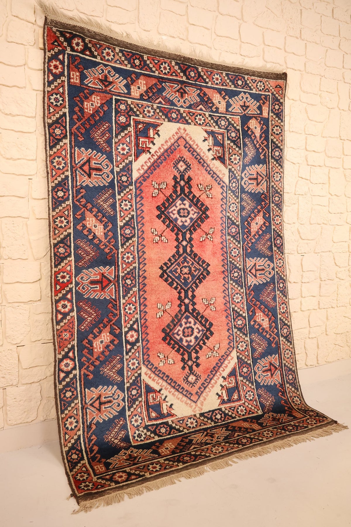 Tapis Dodgem Alti rose et bleu vu de biais, champ saumon et large bordure bleue