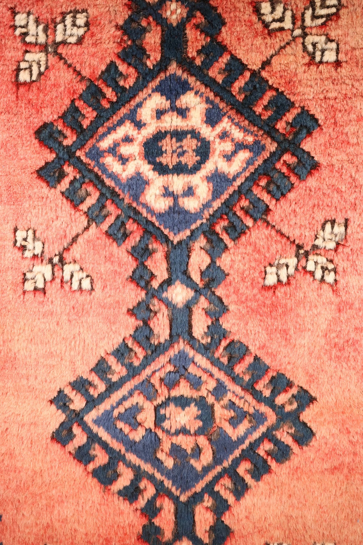 Détail des losanges étoilés bleu et ivoire au centre du tapis Dodgem Alti rose