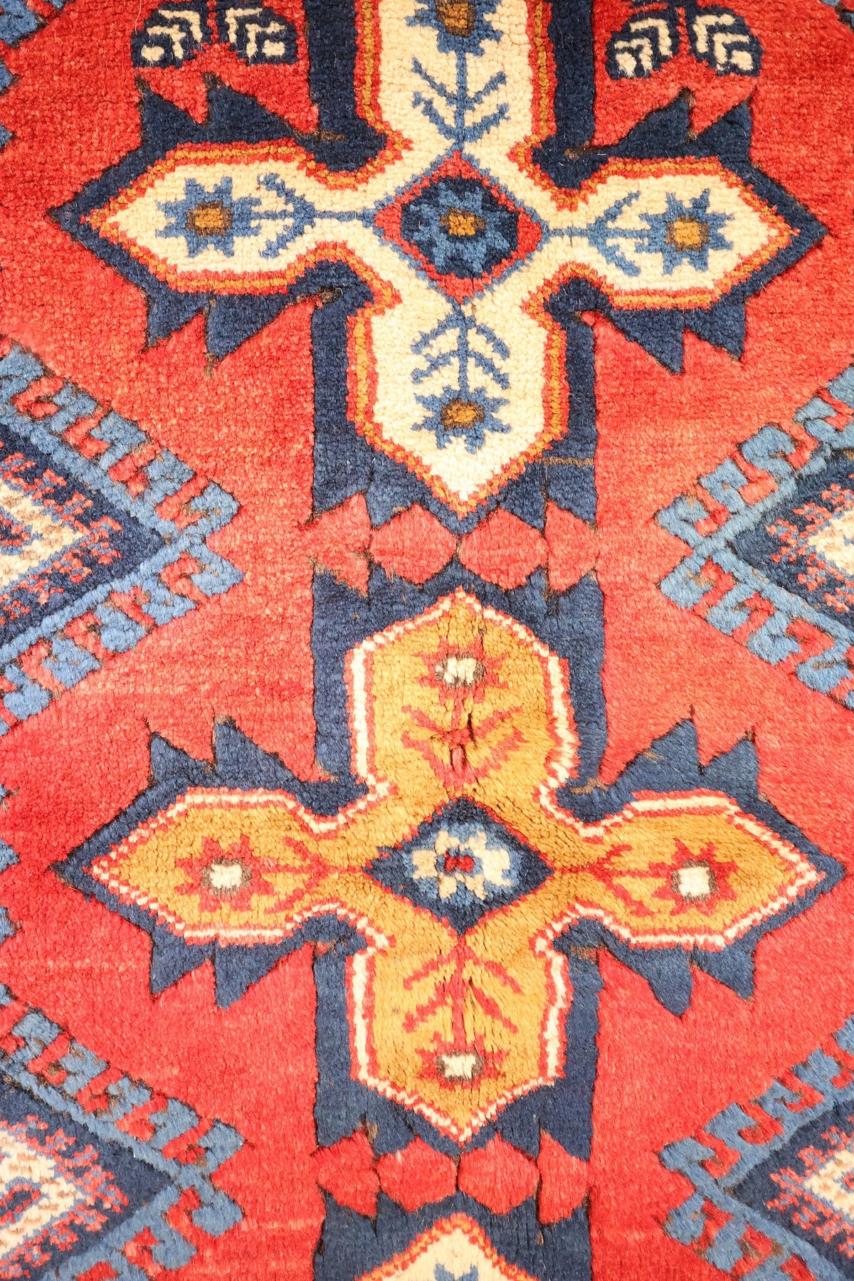 Détail des médaillons cruciformes ivoire et jaune-orangé sur champ rouge