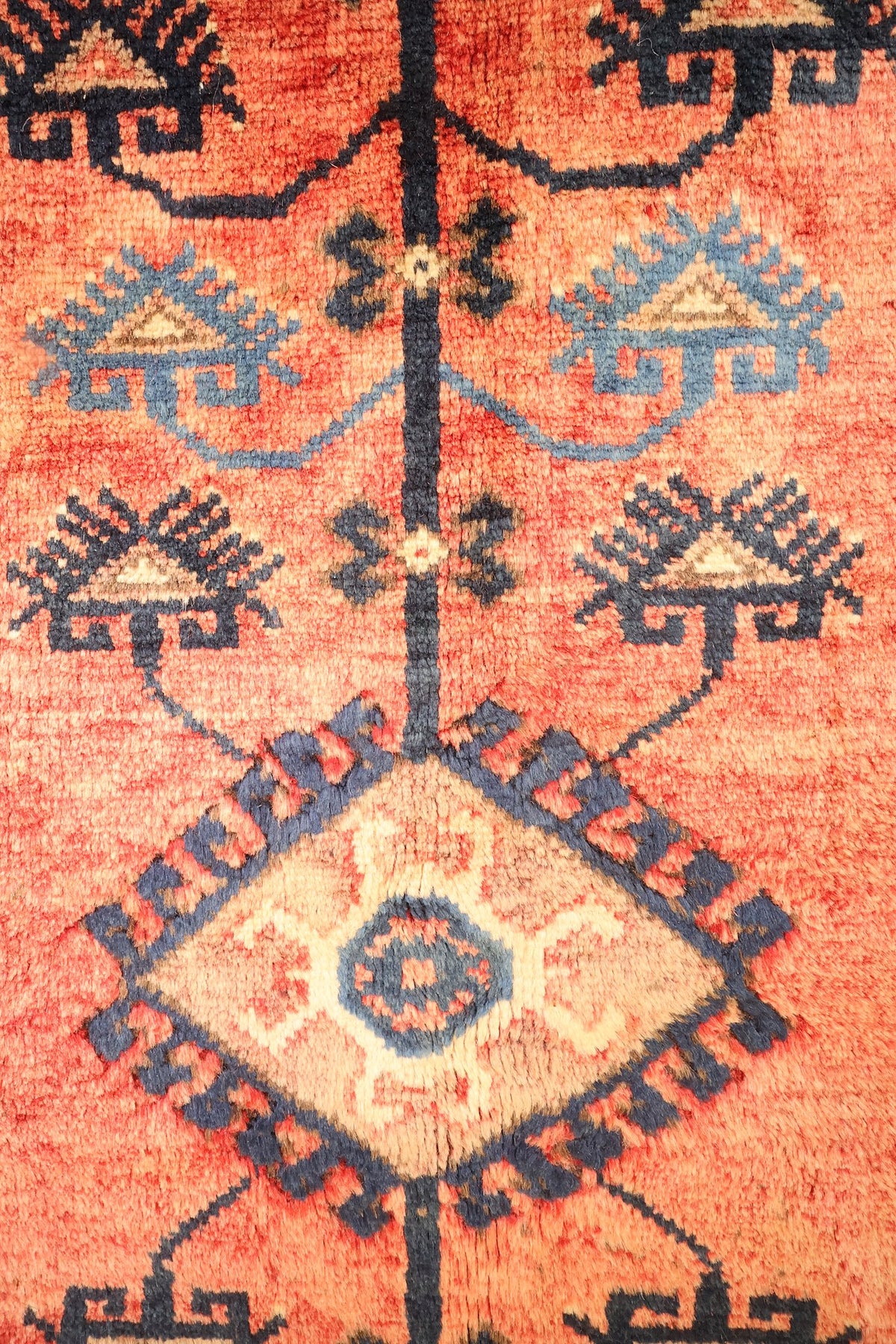 Détail du médaillon losangé beige à centre bleu et des motifs crochetés par paires, tapis Dodgem Alti