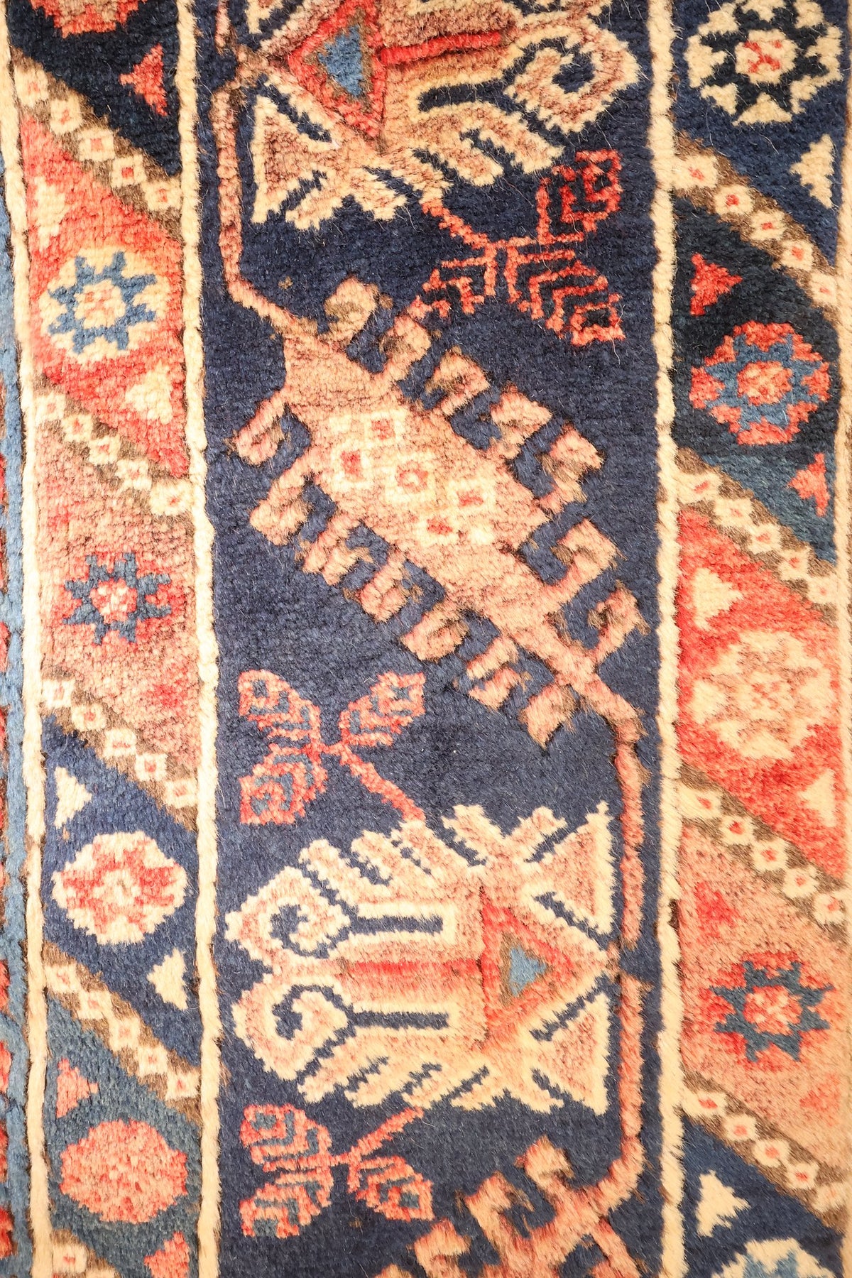 Bordure bleu nuit du tapis Dodgem Alti, étoiles et triangles beiges et rouges, galons à chevrons