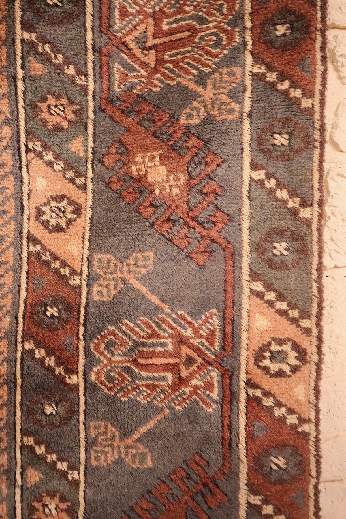 Bordure gris-bleu à motifs anguleux et contre-bordures à rosettes du tapis Dodgem Alti