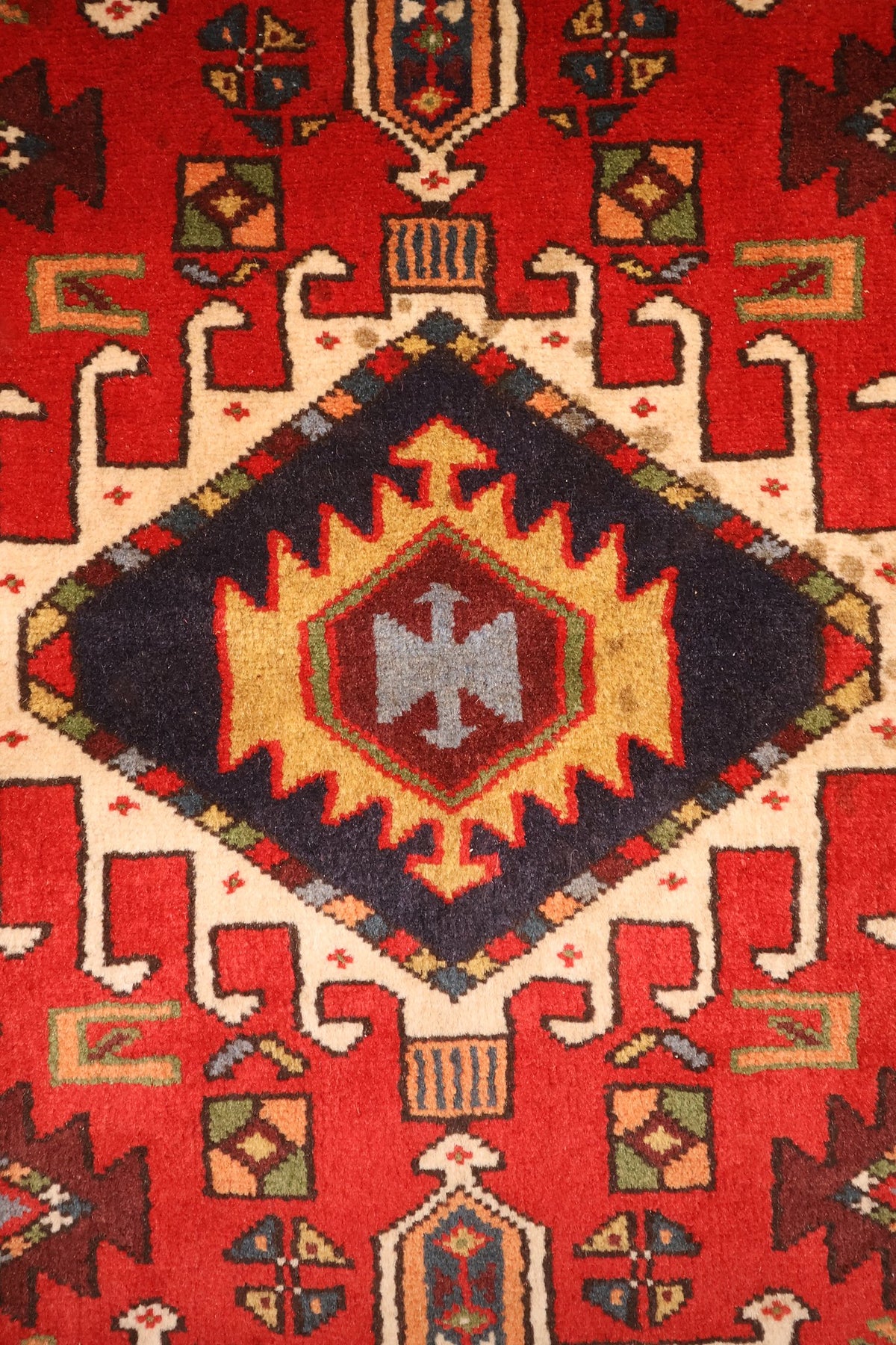 Détail du losange bleu nuit central à hexagone jaune et rouge du tapis Garadgeh