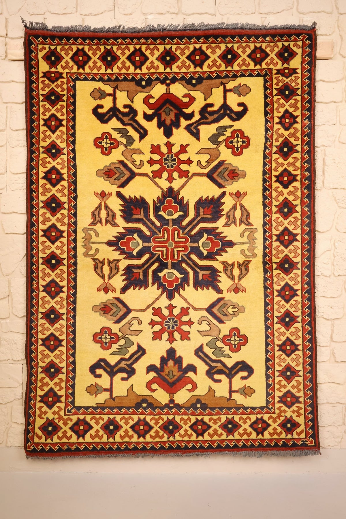 Tapis Ghazni jaune 161 × 110 cm, vue d'ensemble du médaillon central bleu et rouge
